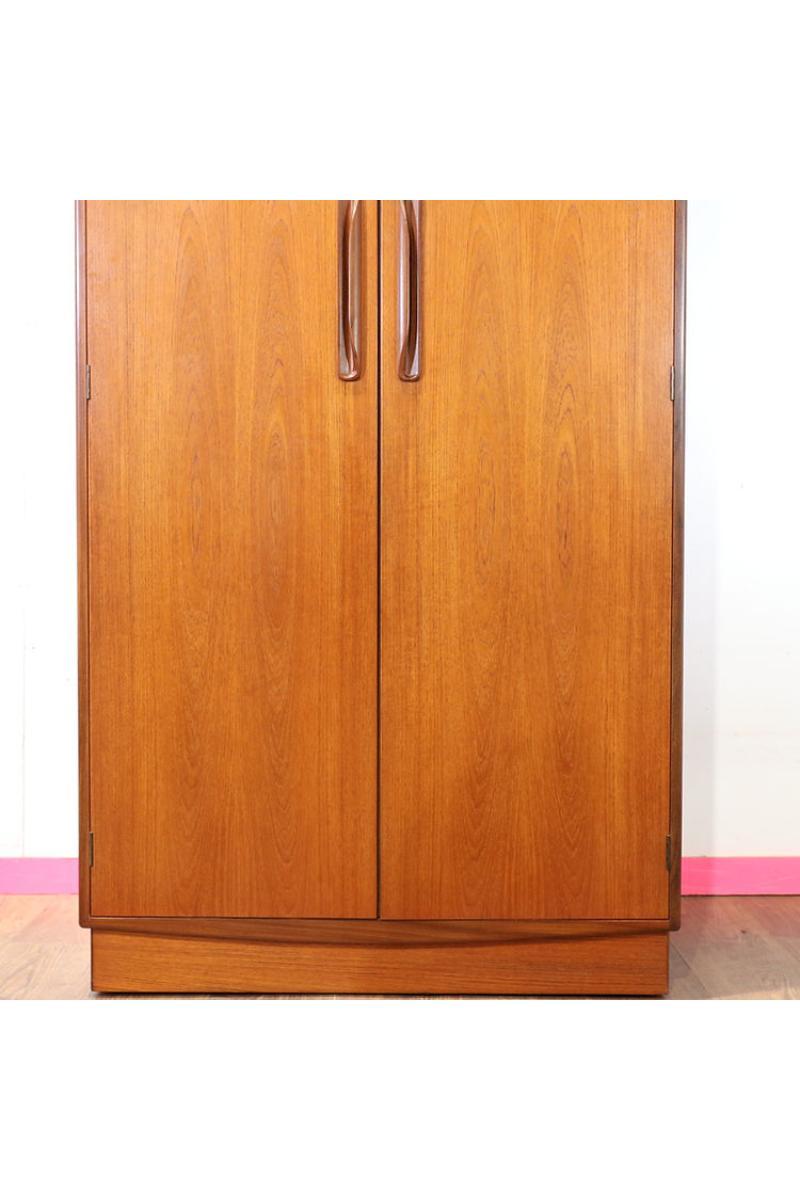 This stunning mid century modern vintage teak armoire by G Plan is a must-have for any lover of classic mid century furniture. Crafted from beautiful teak wood, this piece exudes timeless style and elegance. With a spacious interior featuring a