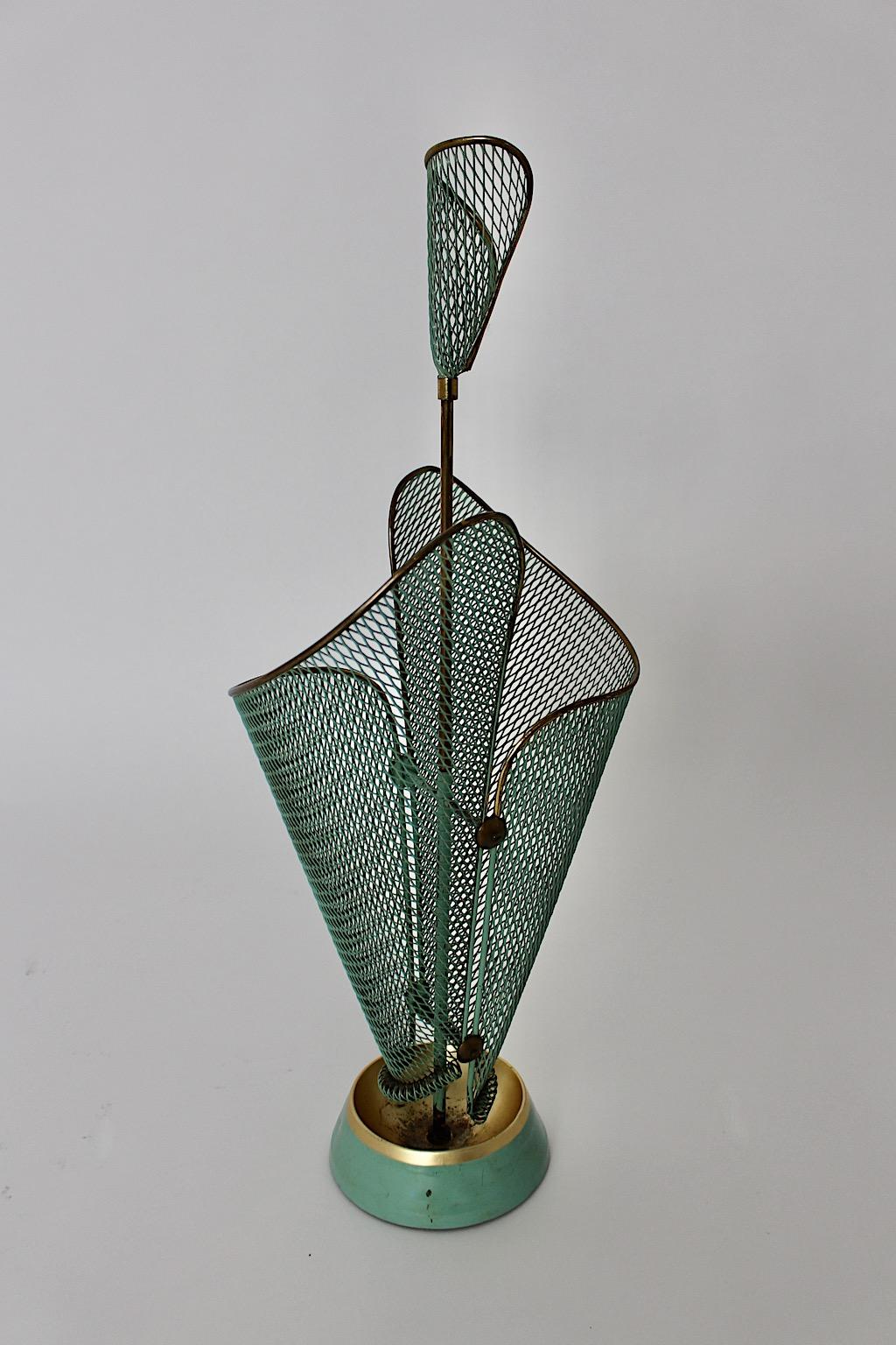 Mid-Century Modern vintage umbrella Stand from metal in teal green color tone by Schiwa Luxus 1950s Germany.
A stunning umbrella Stand from metal mesh in teal green and brass details with a cast iron base and an integrated drip cup.
The perforated