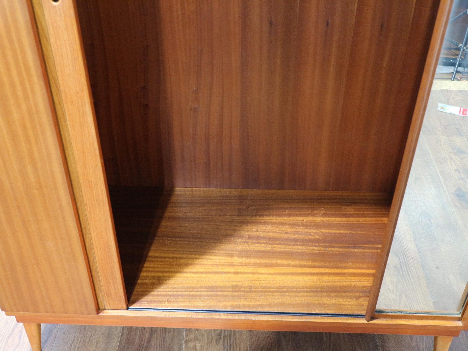 Introducing this Mid Century Modern Vintage Teak Tripple Armoire with Tambour Door by Austinsuite, a stunning addition to any mid century furniture collection. This British-made piece is a true representation of the craftsmanship and design of the