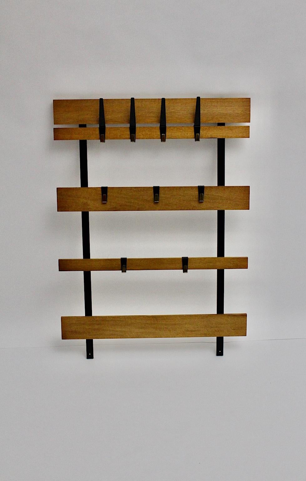 Mid-Century Modern vintage oak wall-mounted wardrobe or coat rack with nine loose black lacquered metal hooks.
The natural lacquered oak slats are connected with 2 black lacquered metal profiles, which are very easy to mount at the wall.
The nine