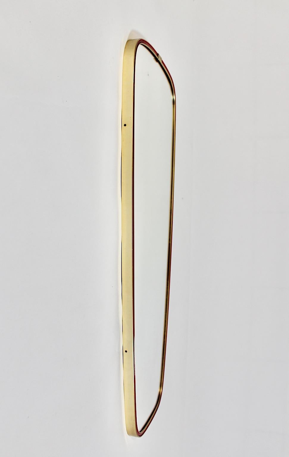 Specchio da pavimento vintage Mid Century Modern specchio da parete a figura intera in ottone con rivestimento in plastica rossa come caratteristica accattivante, progettato e realizzato negli anni '50.
Un meraviglioso specchio da terra di forma