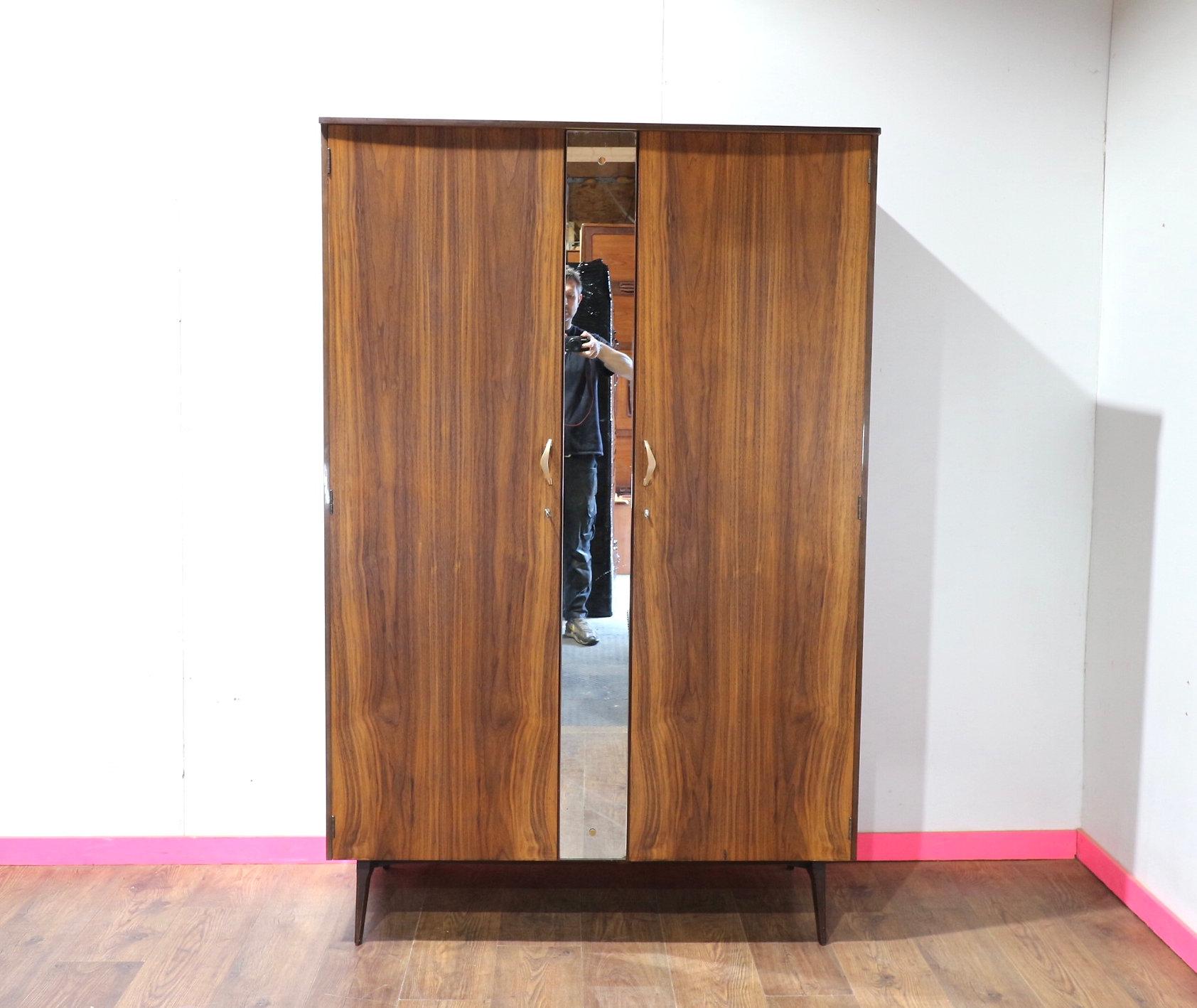 Scopri l'eleganza senza tempo di questo Armadio Vintage in noce del Mid Century Modern di Meredew, disponibile su Mid Century Traders. Questo pezzo pregiato offre non solo un'estetica sofisticata, ma anche un'eccezionale funzionalità per riporre la