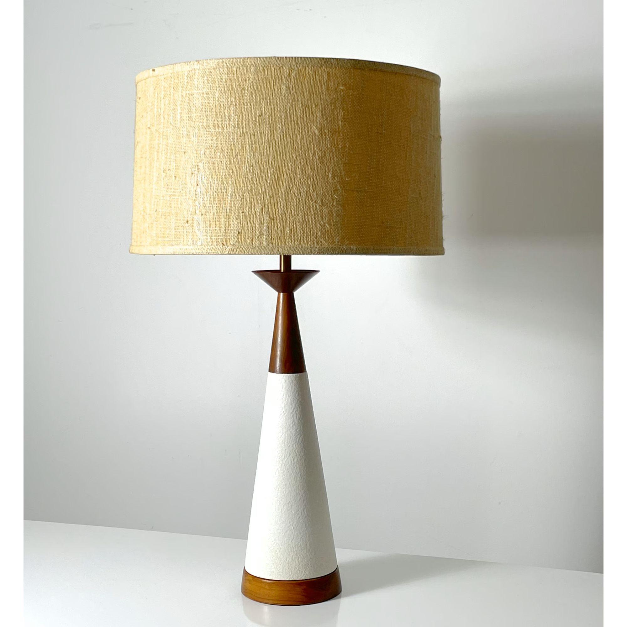Vintage Mid Century Modern White Ceramic Cone Table Lamp 1960s

Stunning modernist table lamp circa 1950s
White ceramic conical form base with sculpted walnut hourglass detail
Complete with original woven shade
Attributed to Michael Lax for Hyalyn /