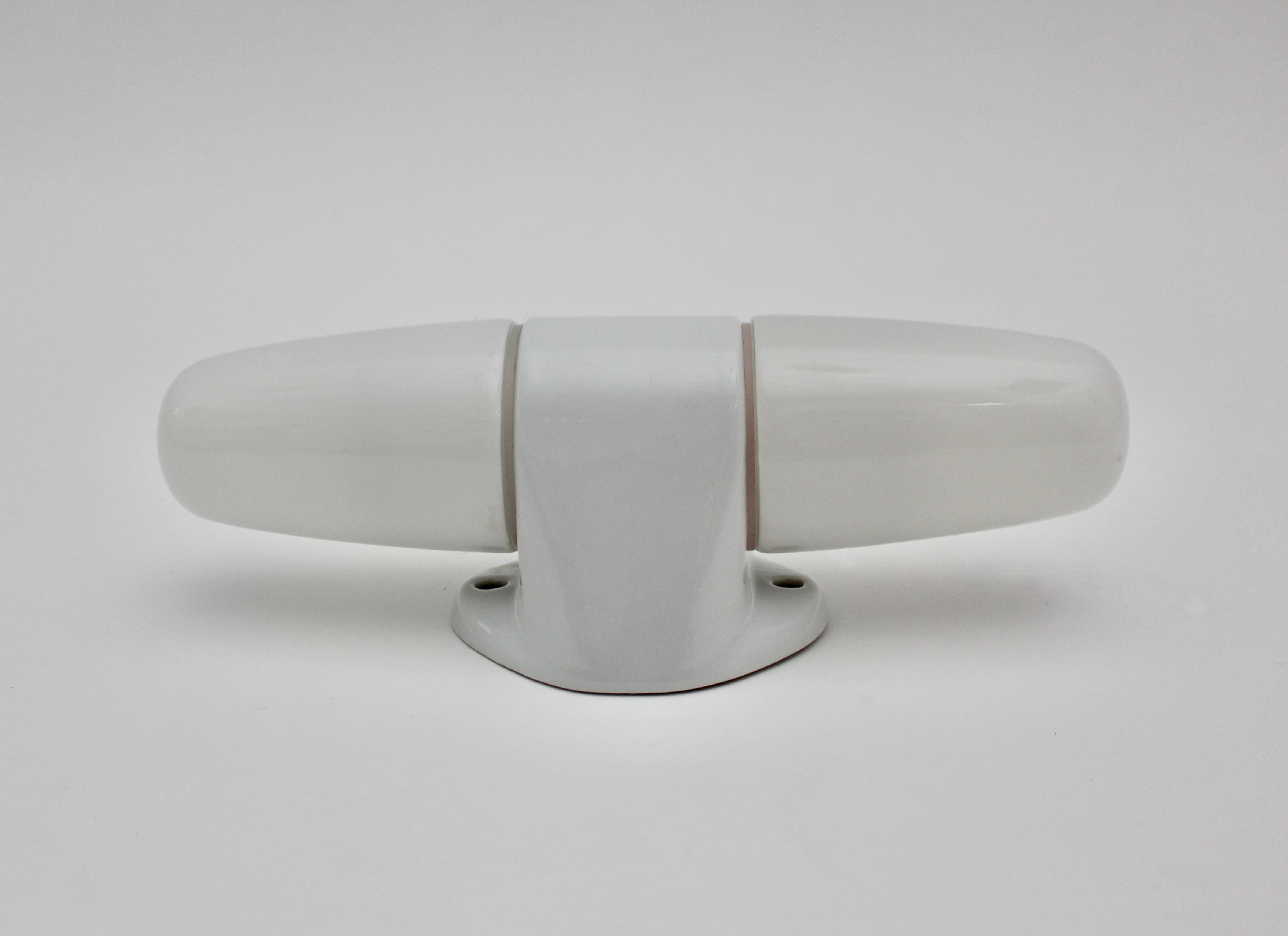 Mid-Century Modern Bauhaus style vintage white glass ceramic sconce or 
wall light by Wilhelm Wagenfeld for Lindner 1950s.
An iconic Bauhaus style vintage sconce by Wilhelm Wagenfeld in sleek and simple white color.
This sconce has two E 14