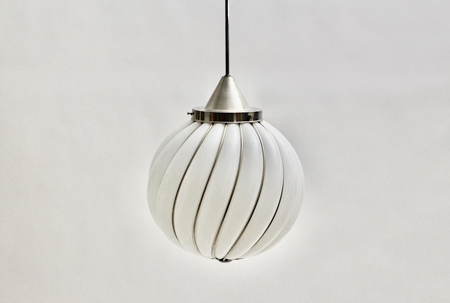 Mid-Century Modern Vintage white glass nickel pendant or hanging lamp by Adolf Loos for Veart Murano, Italy 1960s.
The handmade and high-quality craftsmanship pendant features a white glass ball with nickel plated metal lines.
The slightly curved