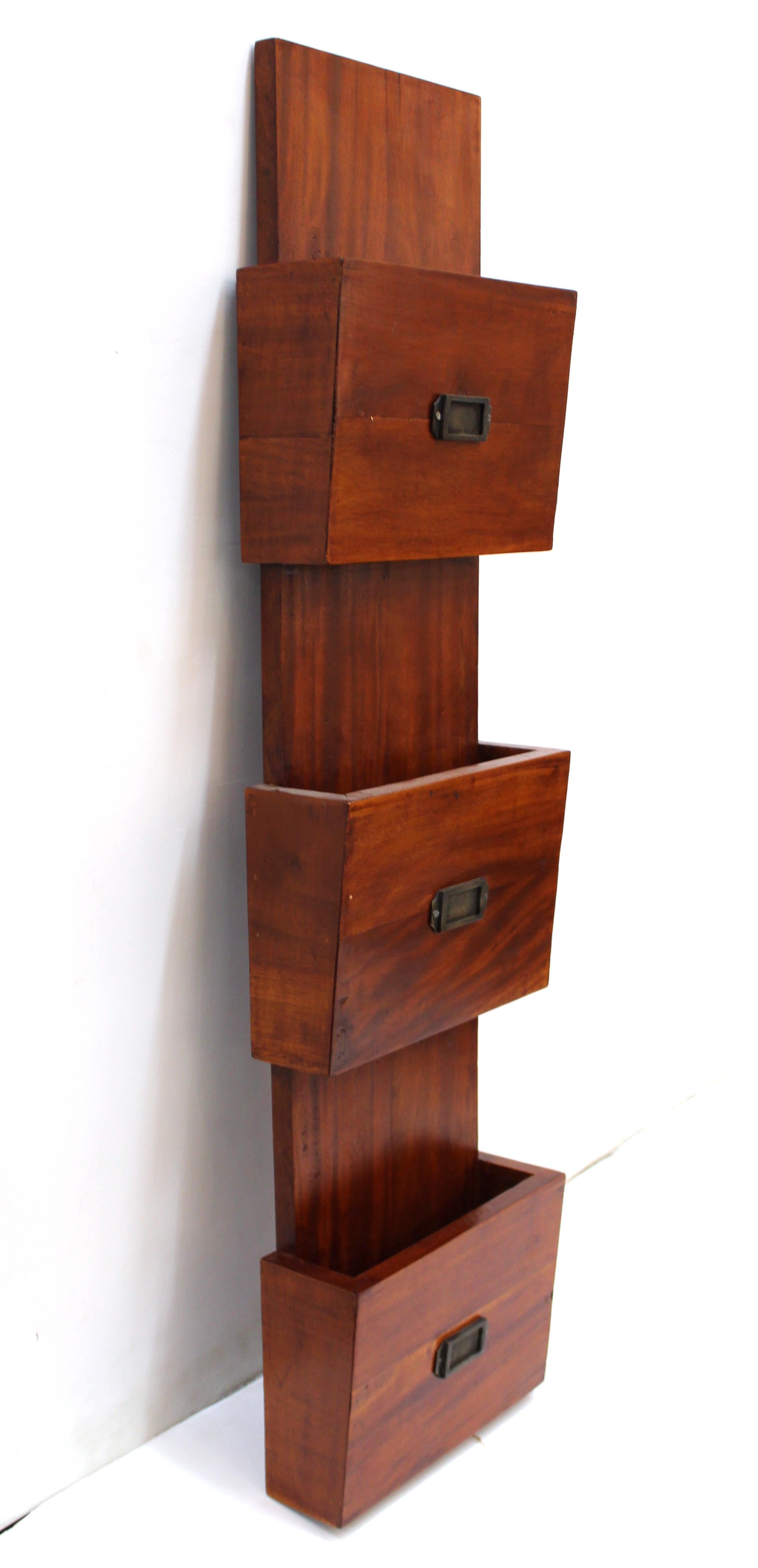 Mid-Century Modern wooden wall-mounted document holder with three separate sections for documents, each one having a metal tag holder. The piece has two hinges on the back to attach to a wall. In great vintage condition.