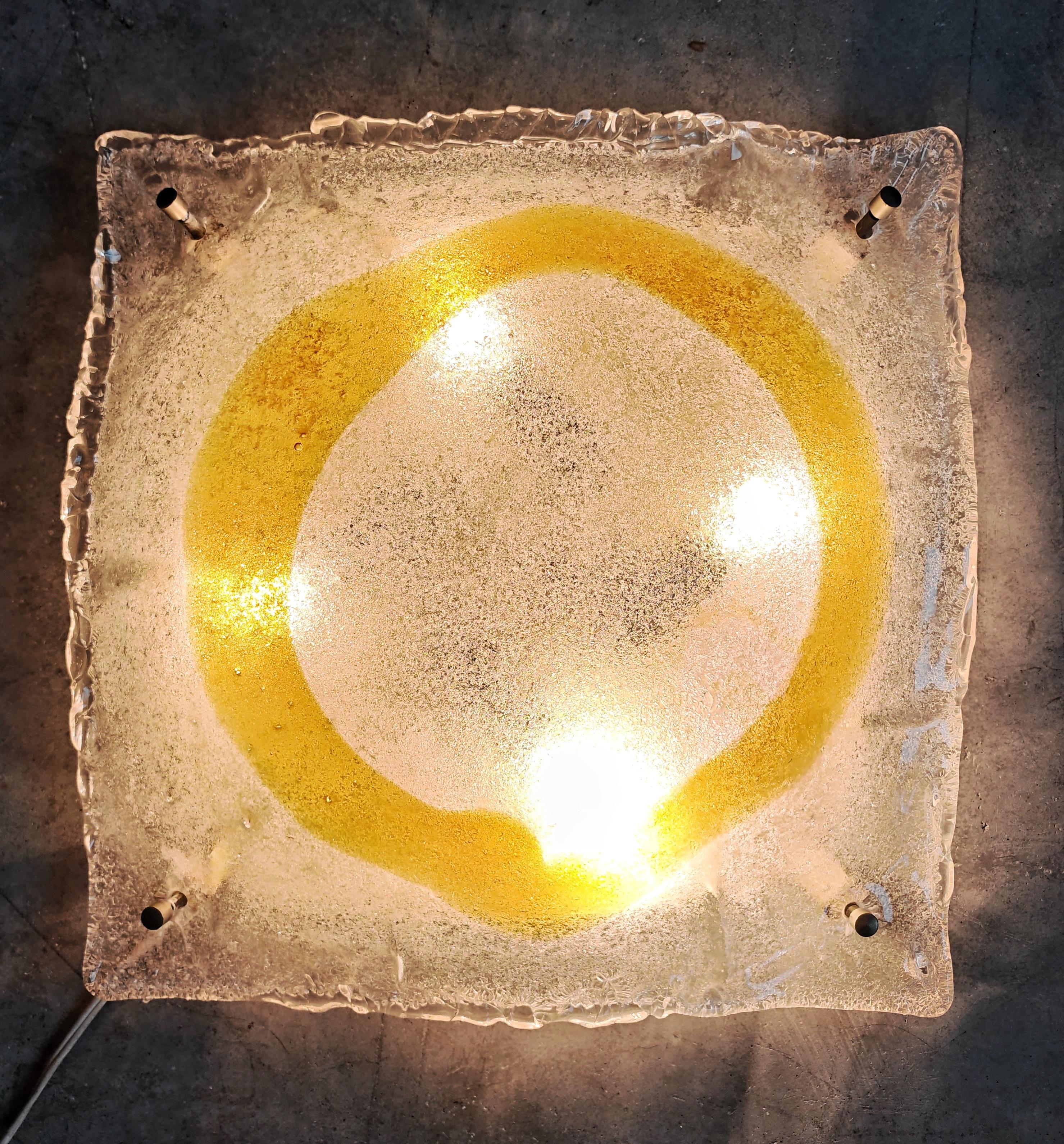 Dans cette annonce, vous trouverez une superbe applique murale ou affleurante de style moderne du milieu du siècle en verre de Murano clair et ambré, attribuée au designer Toni Zuccheri pour le fabricant Mazzega. Le luminaire se compose d'un verre