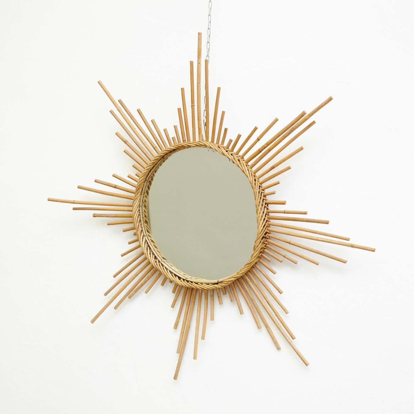 Mid-Century Modern French handcrafted rattan wall mirror.

Infuse your home with the charm of Mid-Century Modern design with this French handcrafted rattan wall mirror, created by an unknown artisan circa 1960. The unique design and intricate