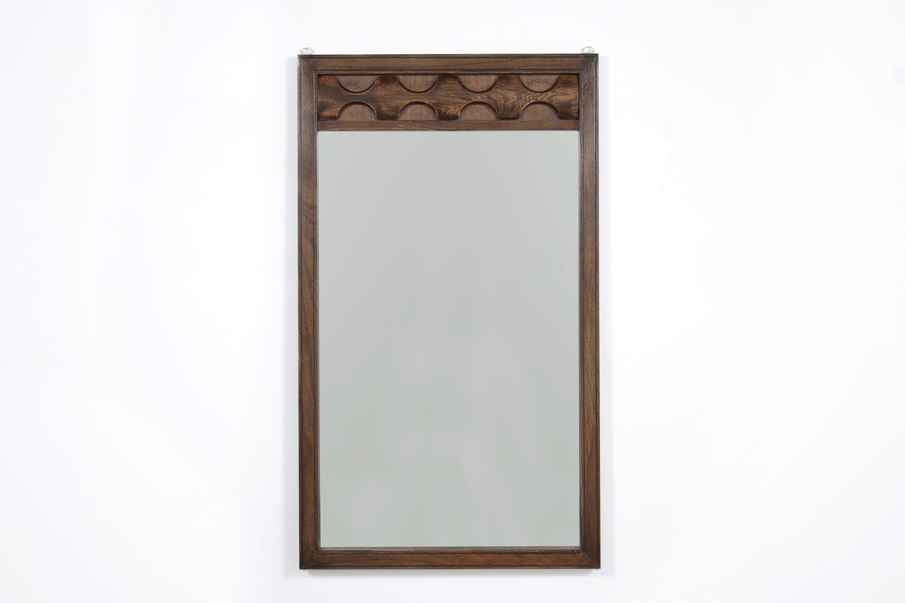 Dive into the captivating world of mid-century design with our exquisite Brutalist-style wall mirror from the 1960s. Every detail, from its masterfully handcrafted wooden frame to the intricately carved sculpted moldings, showcases the unmatched