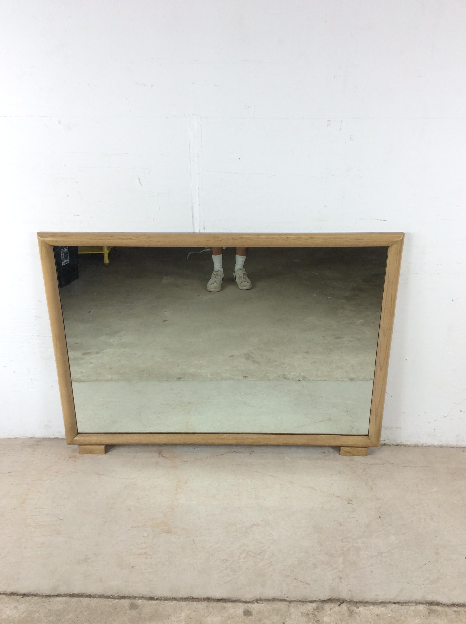 Ce miroir moderne du milieu du siècle est doté d'un cadre en chêne dur, d'une finition en chêne chaulé et d'un bord biseauté, de deux petits pieds rectangulaires en bois et d'un dos en bois massif.

Dimensions : 47w 1d 34.5h

Notes sur l'état : La