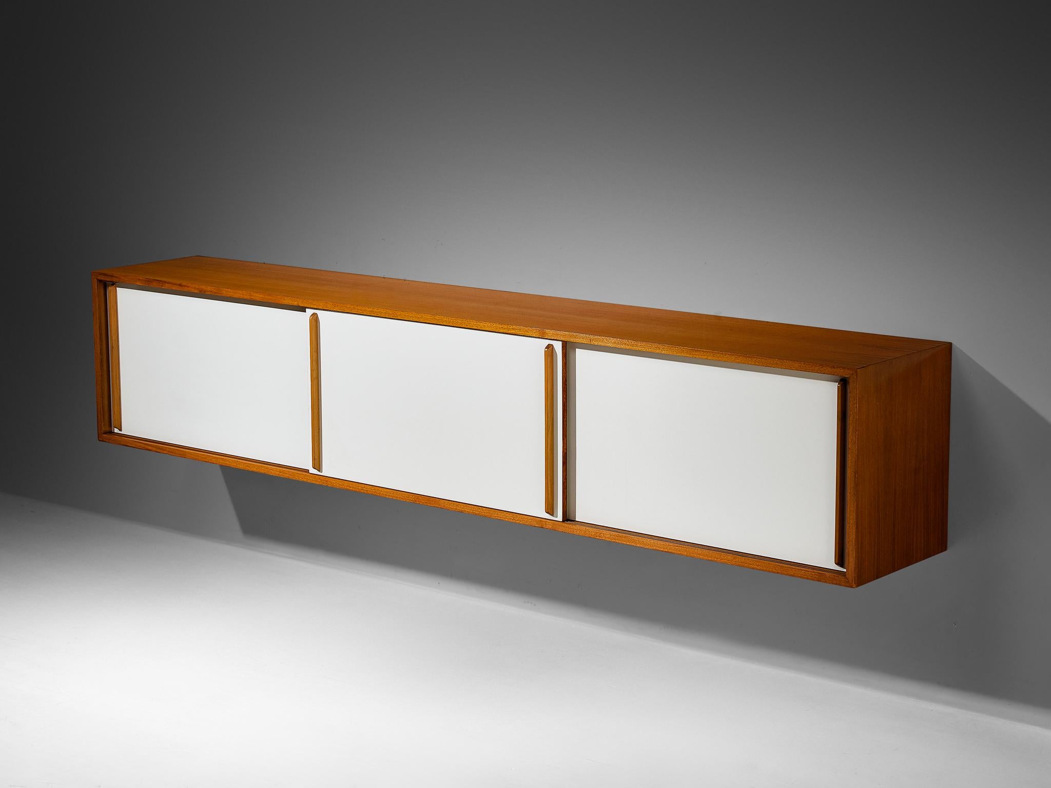 Credenza a muro, noce, legno laminato, Europa, anni '60. 

Elegante armadio a muro degli anni '60. Questa credenza appare molto elegante e sobria, ma si nota il bel dettaglio delle maniglie in noce che spiccano sulle ante in legno laccato bianco.