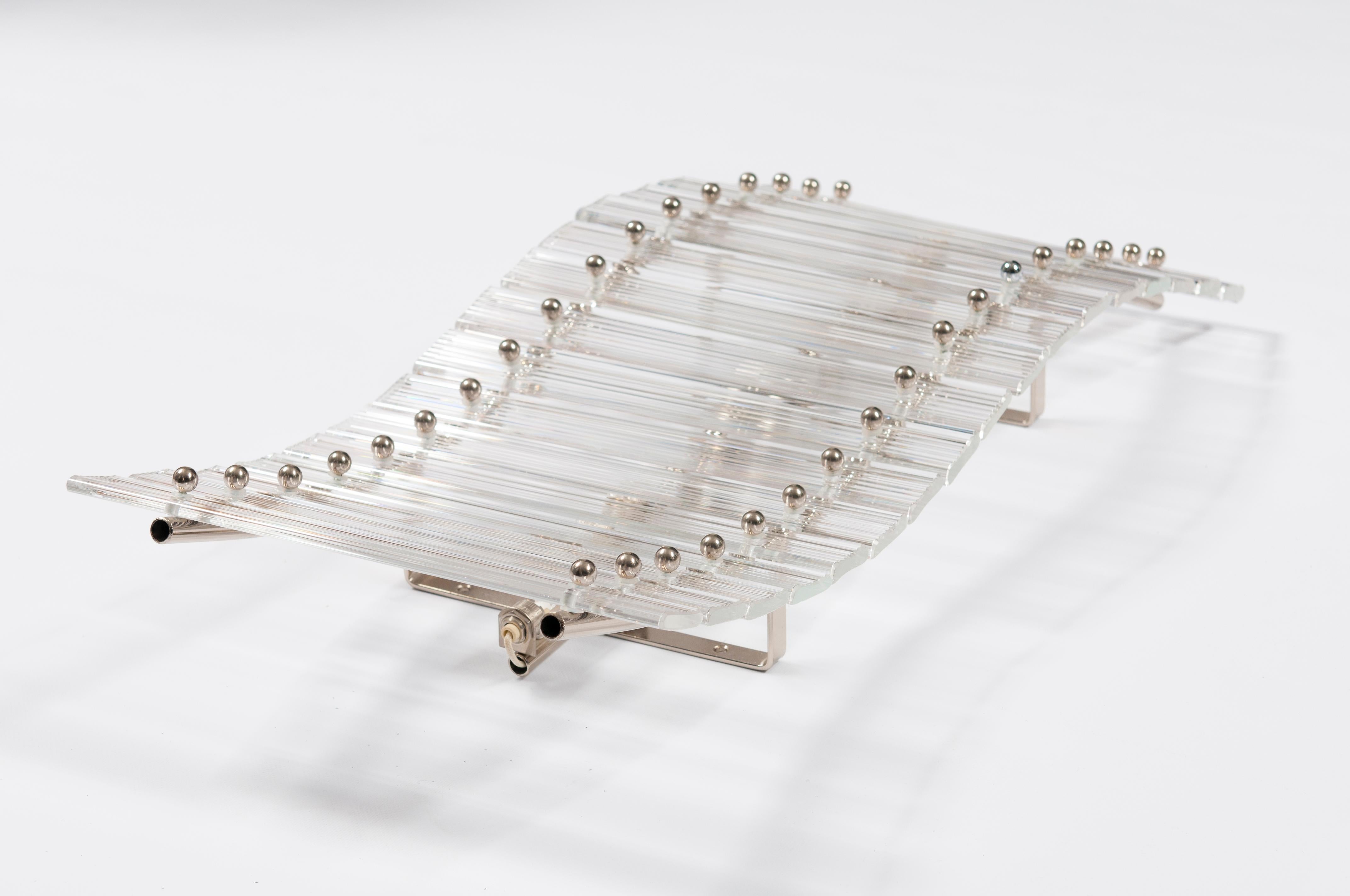 Este impresionante y raro aplique de pared moderno de mediados de siglo es una auténtica obra de arte, procedente de Murano (Italia) en la década de 1970. El candelabro presenta un diseño único compuesto por una serie de varillas de cristal de