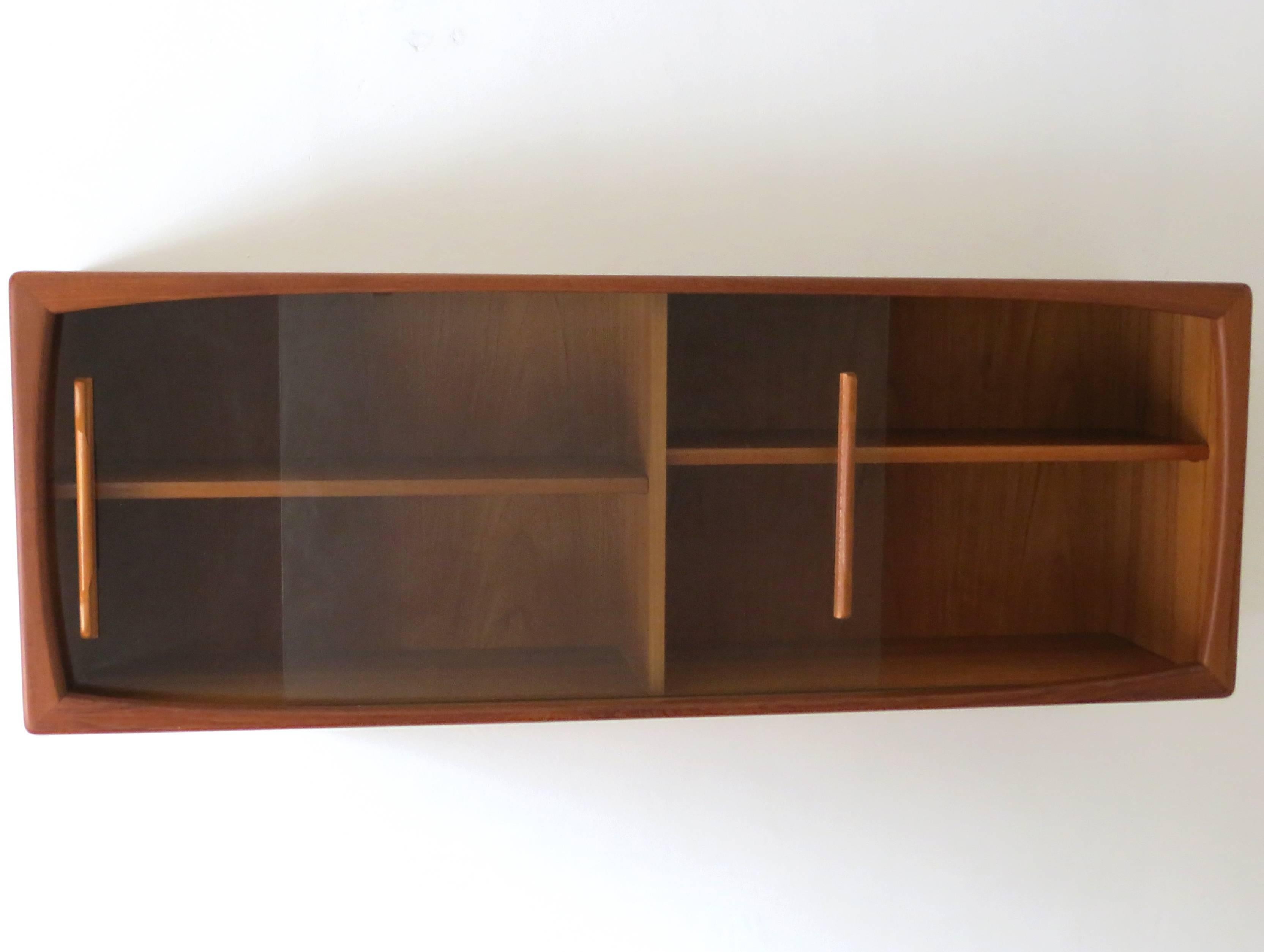 This Danish vintage jewel was designed in the early 1960s by Dyrlund in Denmark.
The character of this design is clean with sculptural lines in typical highest Dyrlund quality. The particularity of this hanging shelf or sideboard are the beautiful