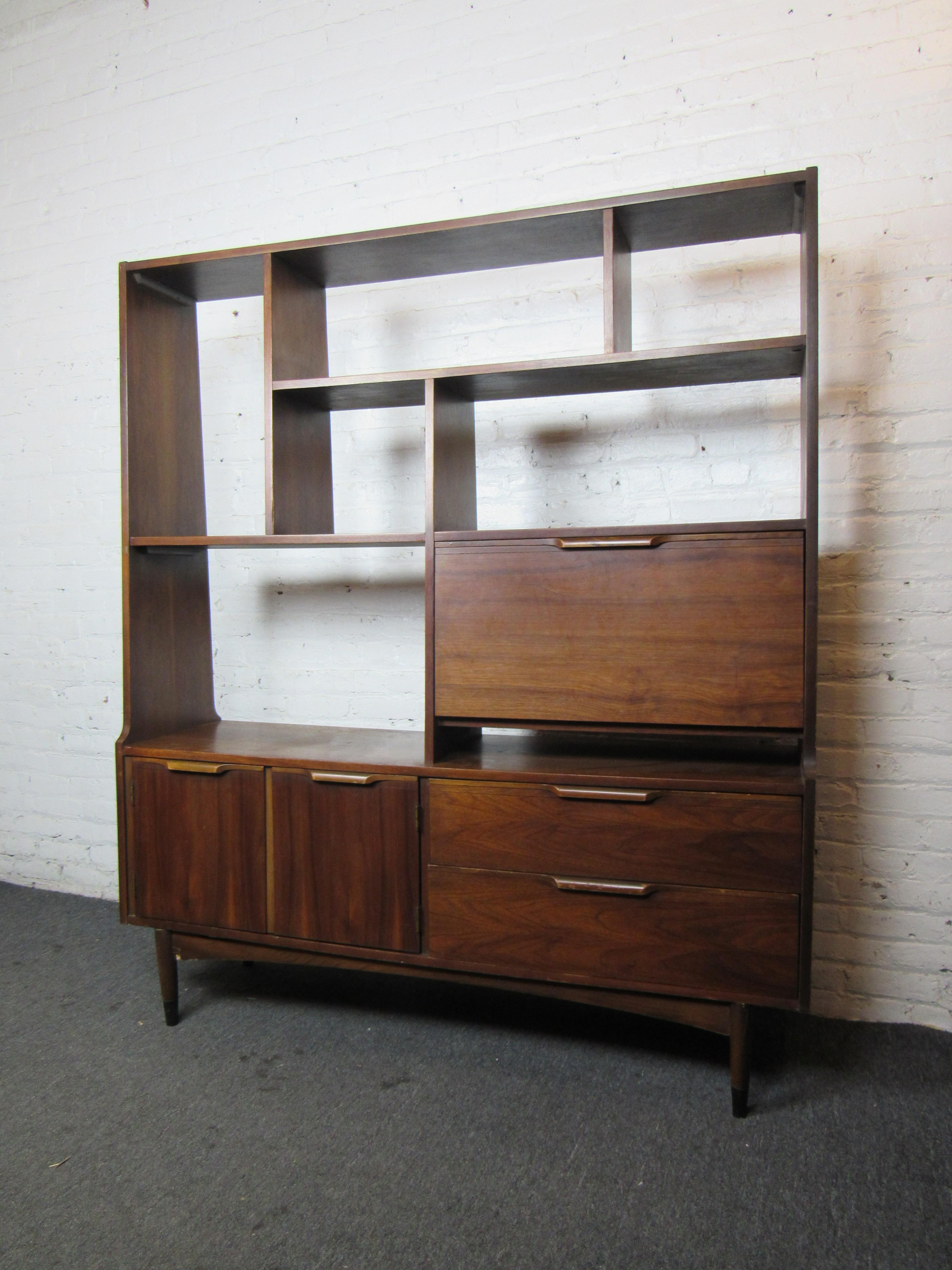 This vintage wall unit offers plenty of storage with an array of shelves and partitions, as well as large storage compartments. One compartment opens to reveal a light for display of items. Please confirm item location with seller (NY/NJ).