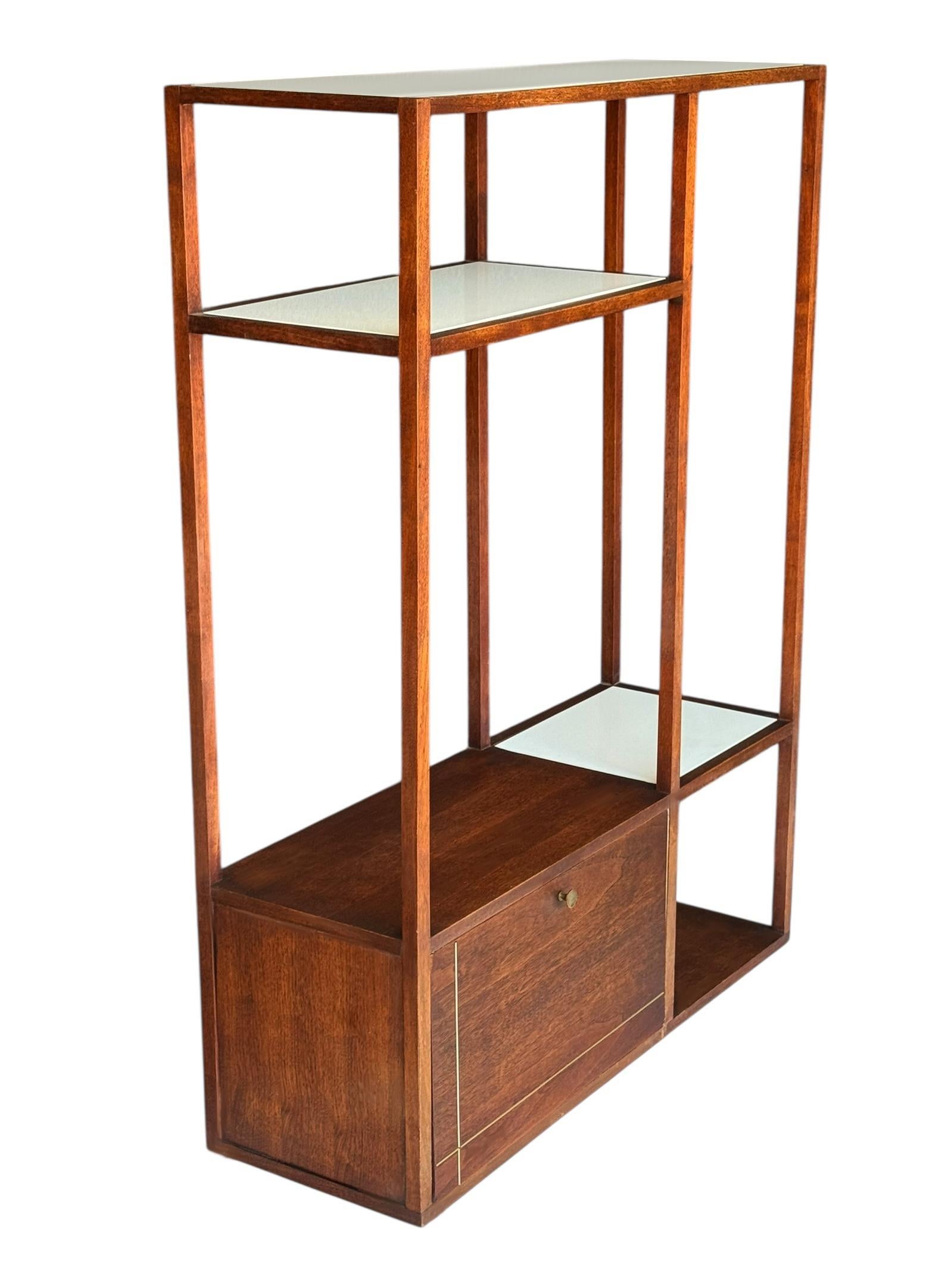 A very cool asymetrical design book shelf or wall unit circa early 1960's.. The unit features walnut framing with inlayed white milk glass shelving. Great mcm high contrast look with some brass accents. Clean and in very good condition. 