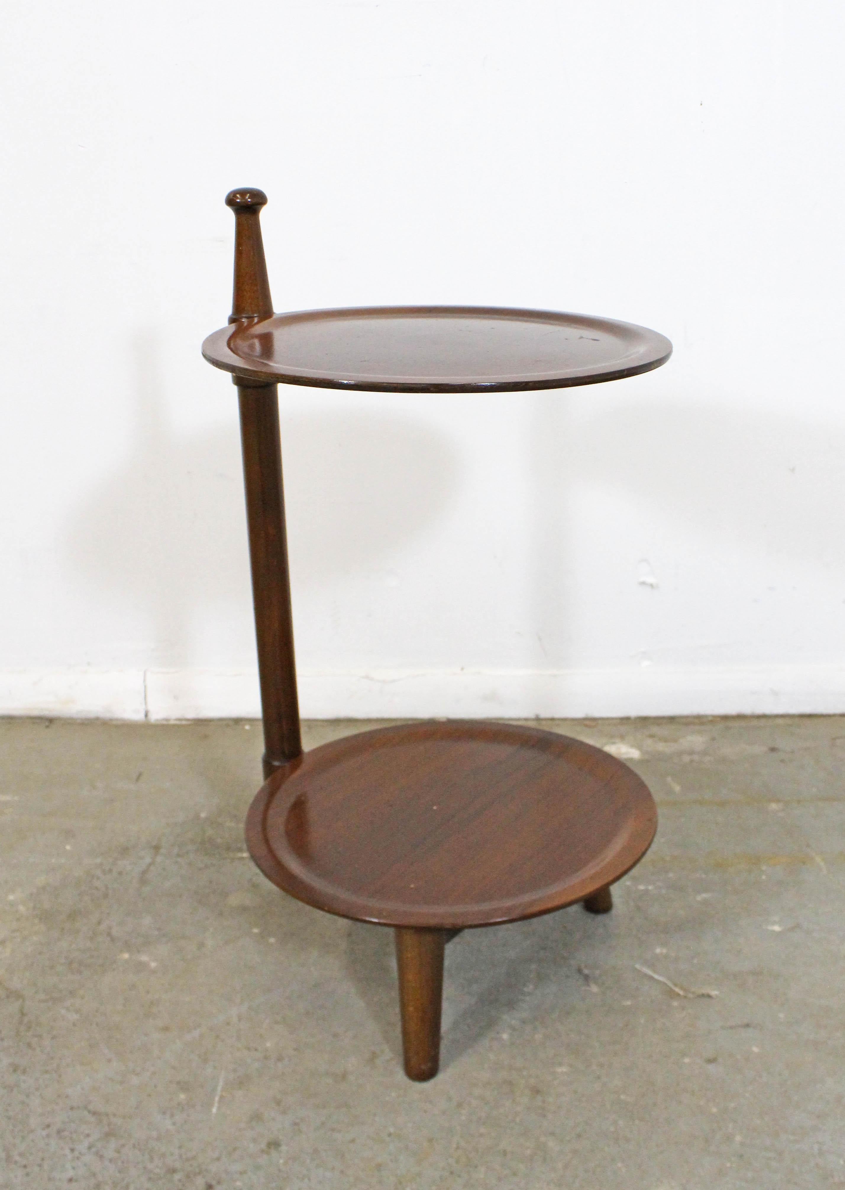 What a find! Offered is a vintage Mid-Century Modern plant stand with great modern look to it. This table looks to be walnut, has 2 round tiers and tapered legs. It is small and light. In good condition with some surface wear/scratches and stains.