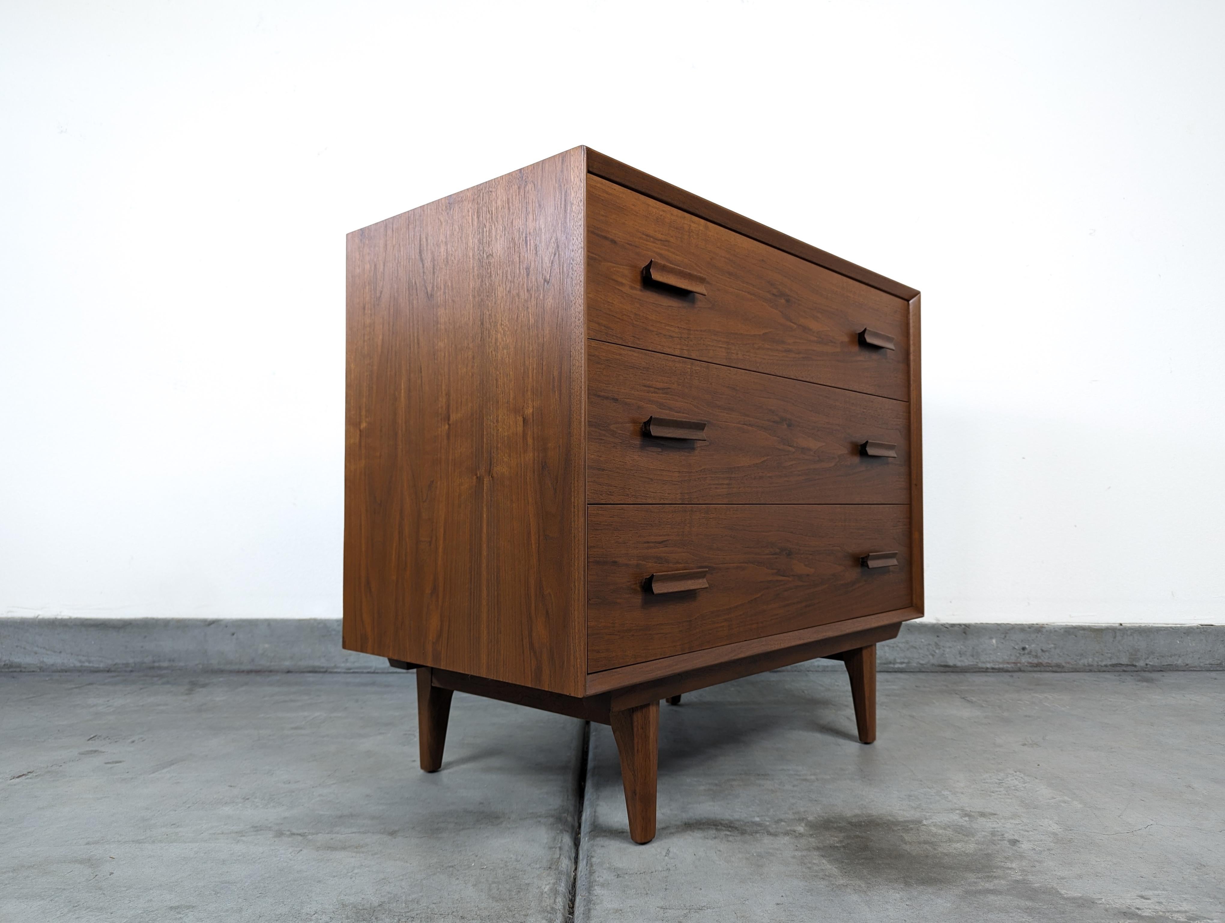 Discover the impeccable craftsmanship and timeless elegance of Scandinavian design with this exquisite vintage Mid-Century Modern walnut chest of drawers from the 1960s. Although its precise origins remain unknown, the essence of Nordic style is