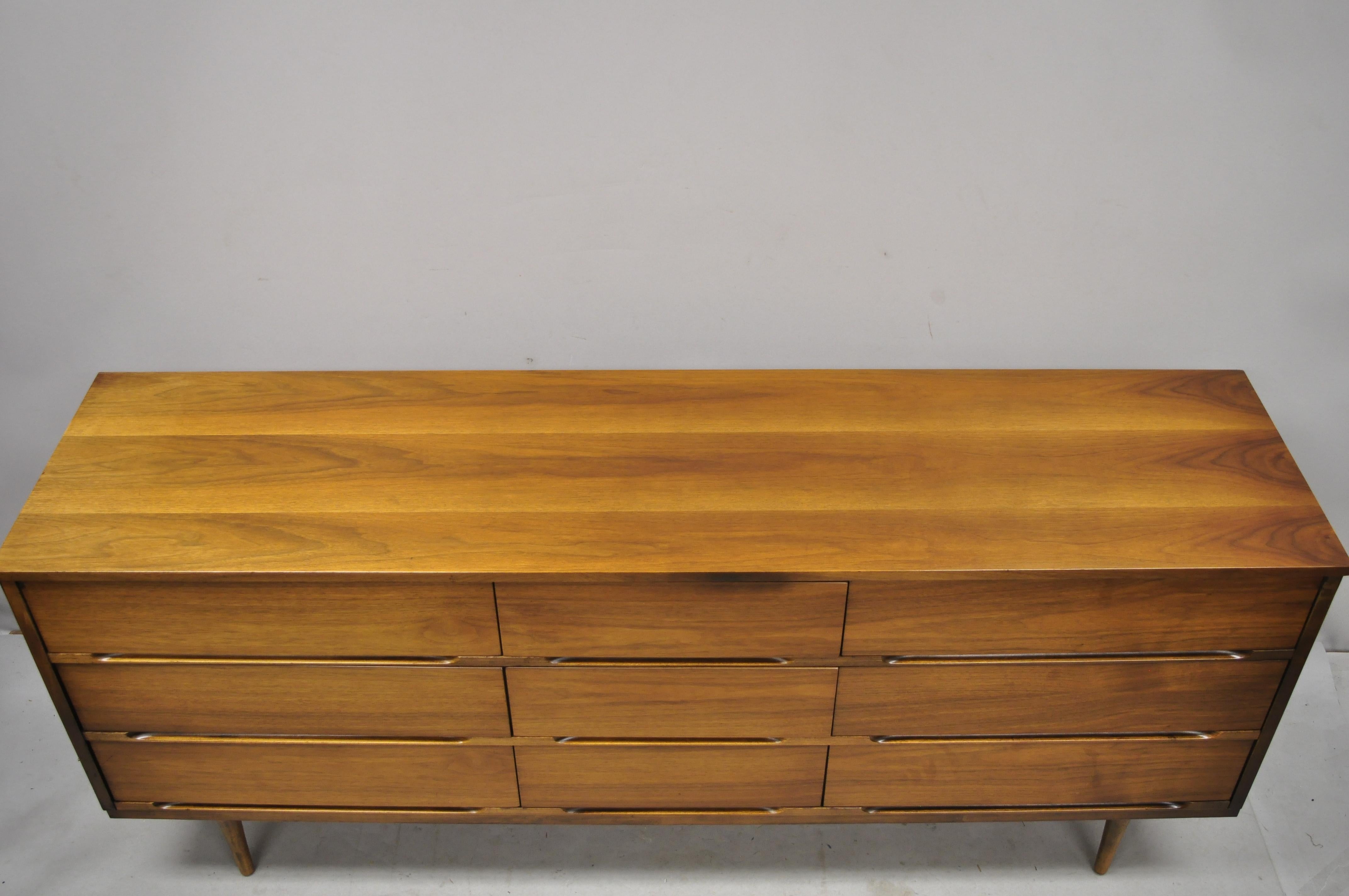 Mid-Century Modern walnut 9-drawer credenza long dresser by Coleman of Virginia. Item features beautiful wood grain, 9 dovetailed drawers, tapered legs, very nice vintage item, clean modernist lines, great style and form, circa mid-20th century.