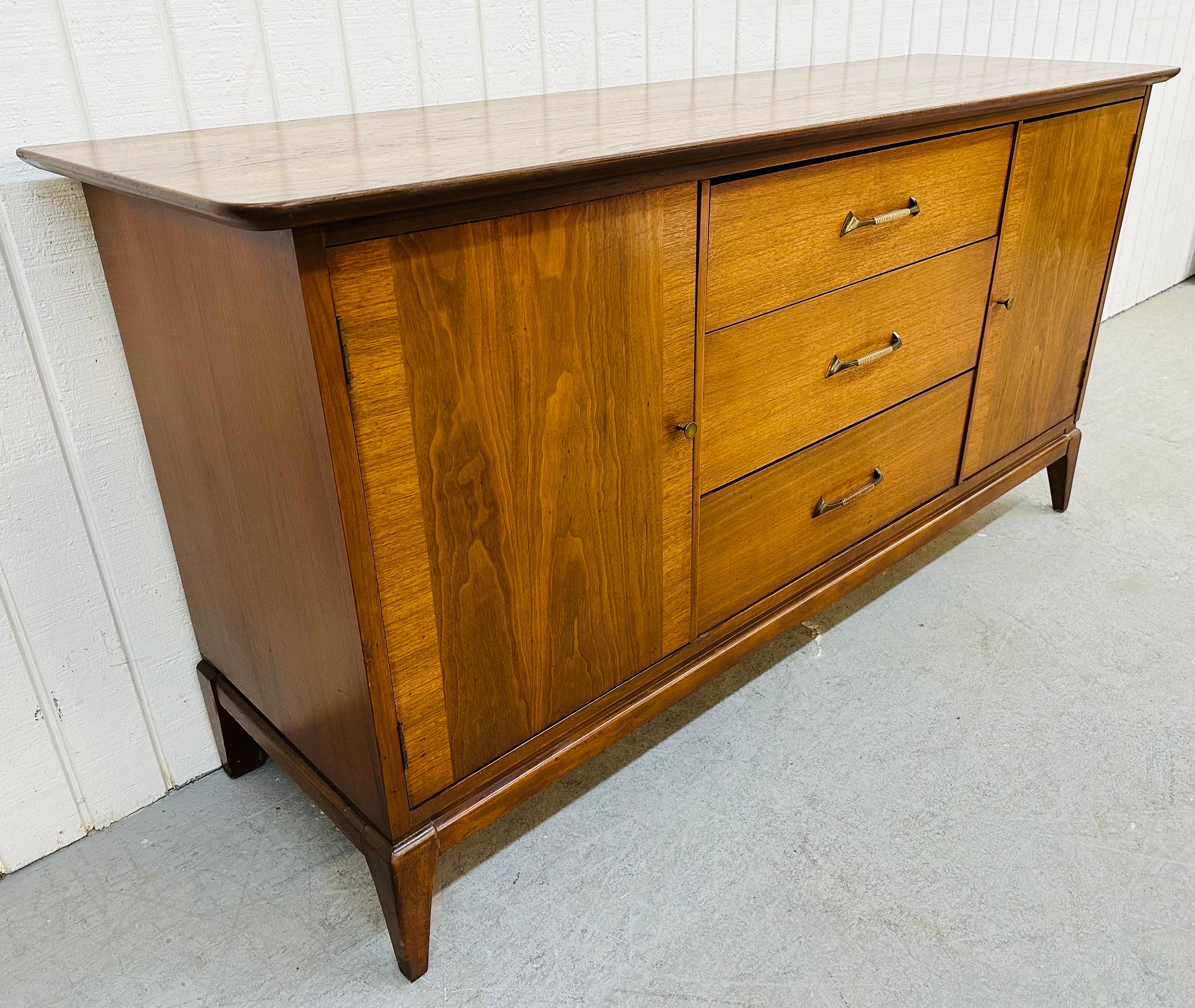 This listing is for a Mid-Century Modern Walnut 9-Drawer Dresser. Featuring a straight line design, three large drawers in the center, doors on each end that open up to three hidden drawers, original hardware, and a beautiful walnut finish. This is