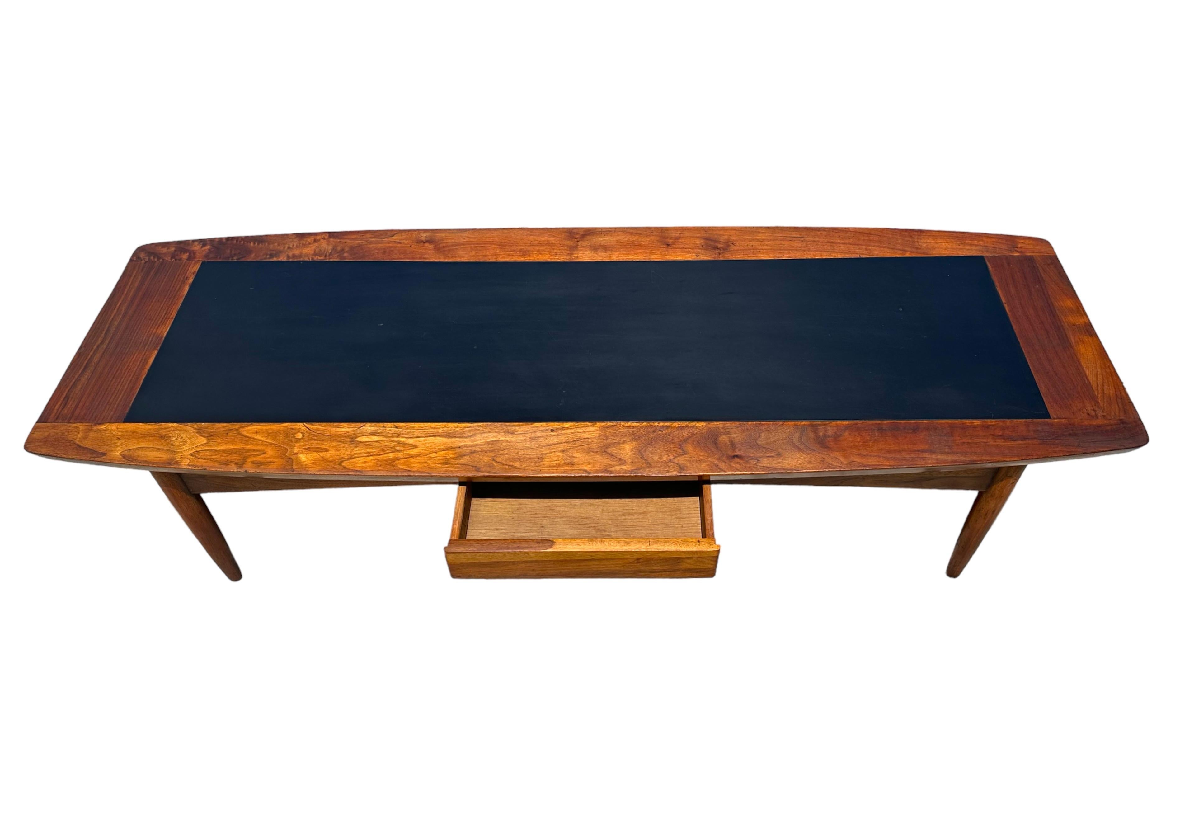 Sleek lines, beautiful and functional. This is a MCM American for Martinsville walnut coffee table. If your looking for a sleek look with room for remote controls, this is it.