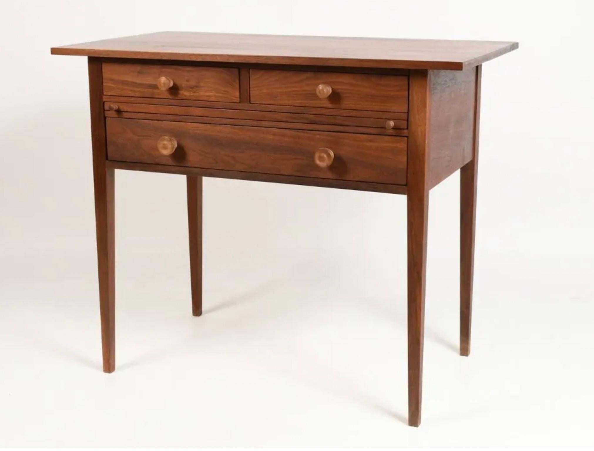 Unique American Studio Craft black walnut writing desk with tapered legs with two small drawers, a pull out surface, and a wide full-size drawer. All expertly crafted using fine woodworking joinery techniques. Has continuous walnut grain across the