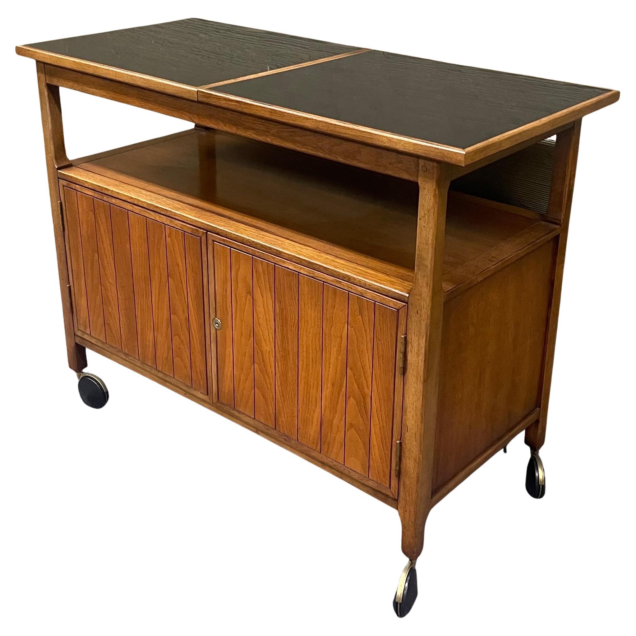 A unique Mid-Century Modern American walnut and black laminate expanding bar cart, circa 1970s. The piece is in good vintage condition and measures 40.25
