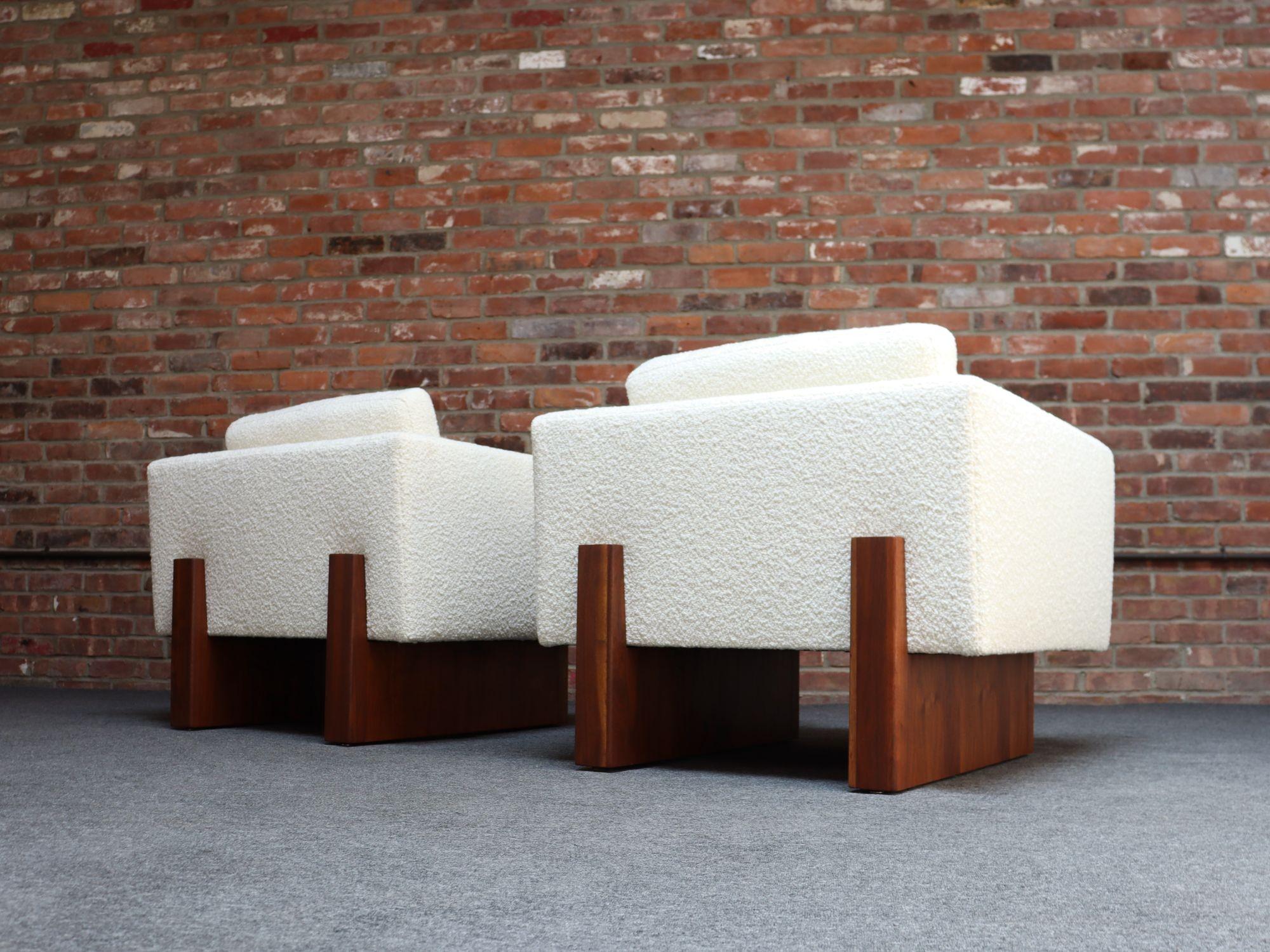 Harvey Probber cube arm/lounge chairs resting on walnut plinth bases which extend out to from vertical uprights, bracketing the back of the frames for added support/style.
Luxurious pair newly reupholstered in a cream Kravet bouclé (36120-1) adding