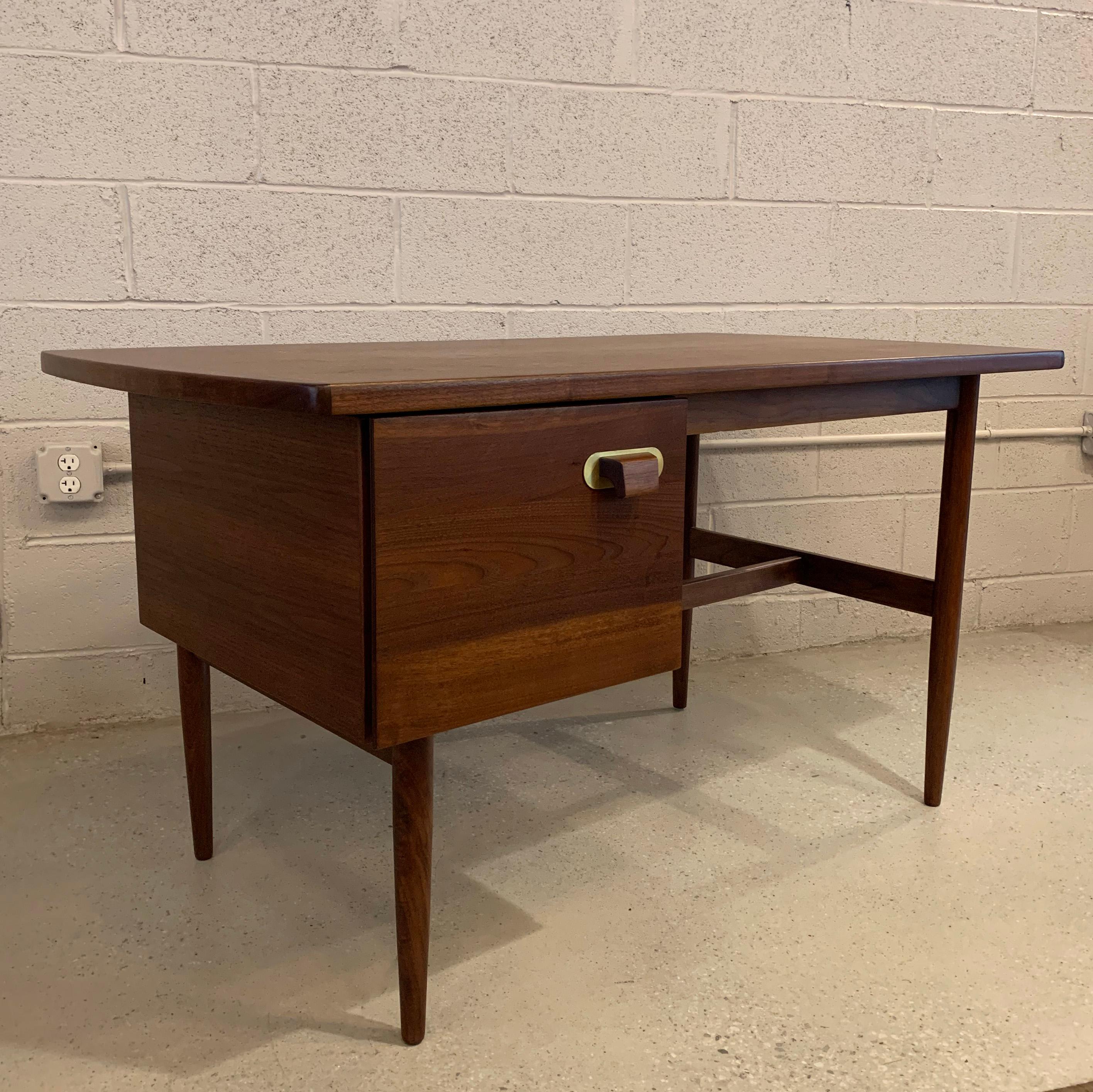 Small, walnut, Mid-Century Modern desk by Jens Risom features a side drawer with diagonal file slats and removable desk organizer with additional storage underneath. The handle features his signature brass backplate. The chair opening measures 24.5