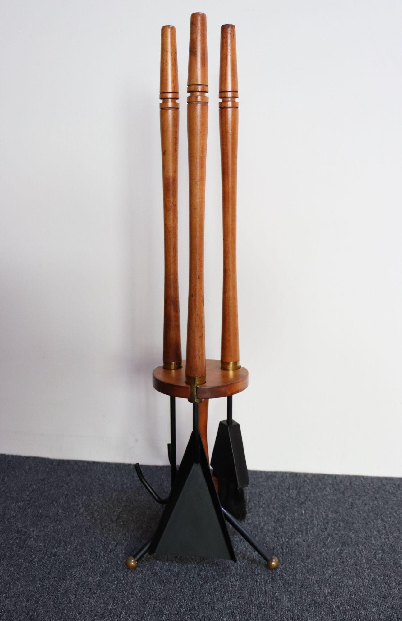 Beautiful, minimal set of Mid-Century Modern fire tools and carrier with carved walnut handles and brass accents. Set is often attributed to Arthur Umanoff, but no supporting documentation has been identified.
Includes the tripod base carrier,