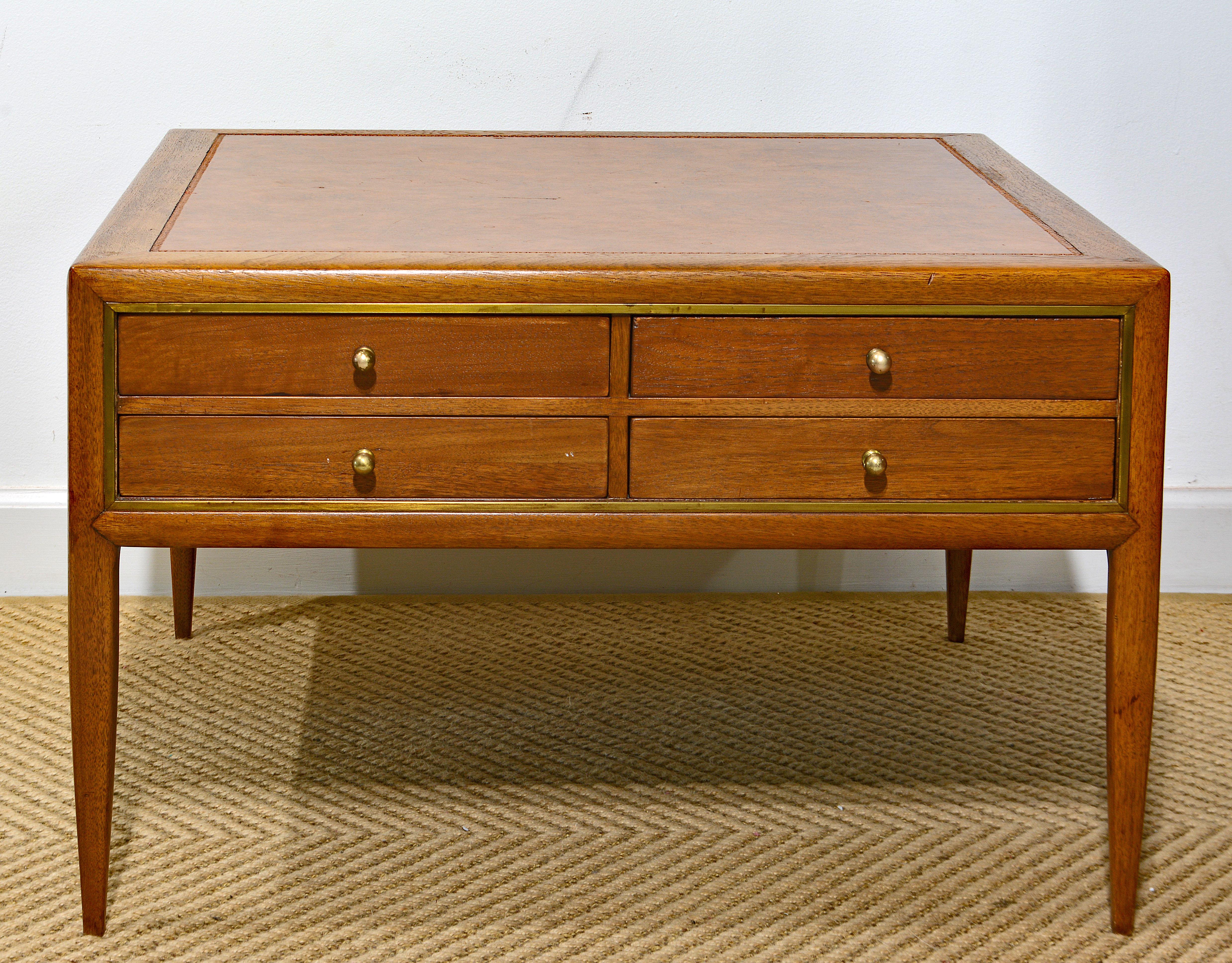 This Mid-Century Modern high end design coffee or cocktail table features a tooled leather top above a section with four drawers designed as serving or TV trays with easy to operate fold out legs. The pull out trays can also serve as an extension of