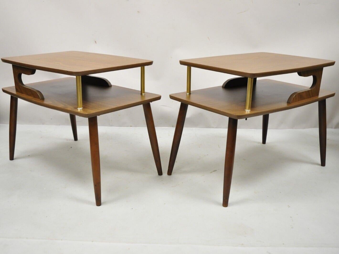 Mid Century Modern Walnut and Laminate Top 2 Tier Step Up End Tables - a Pair. Item features 2 tiers, laminate wood grain tops, tapered legs, brass accents, great style and form. Circa mid 20th Century. Measurements: 20.5