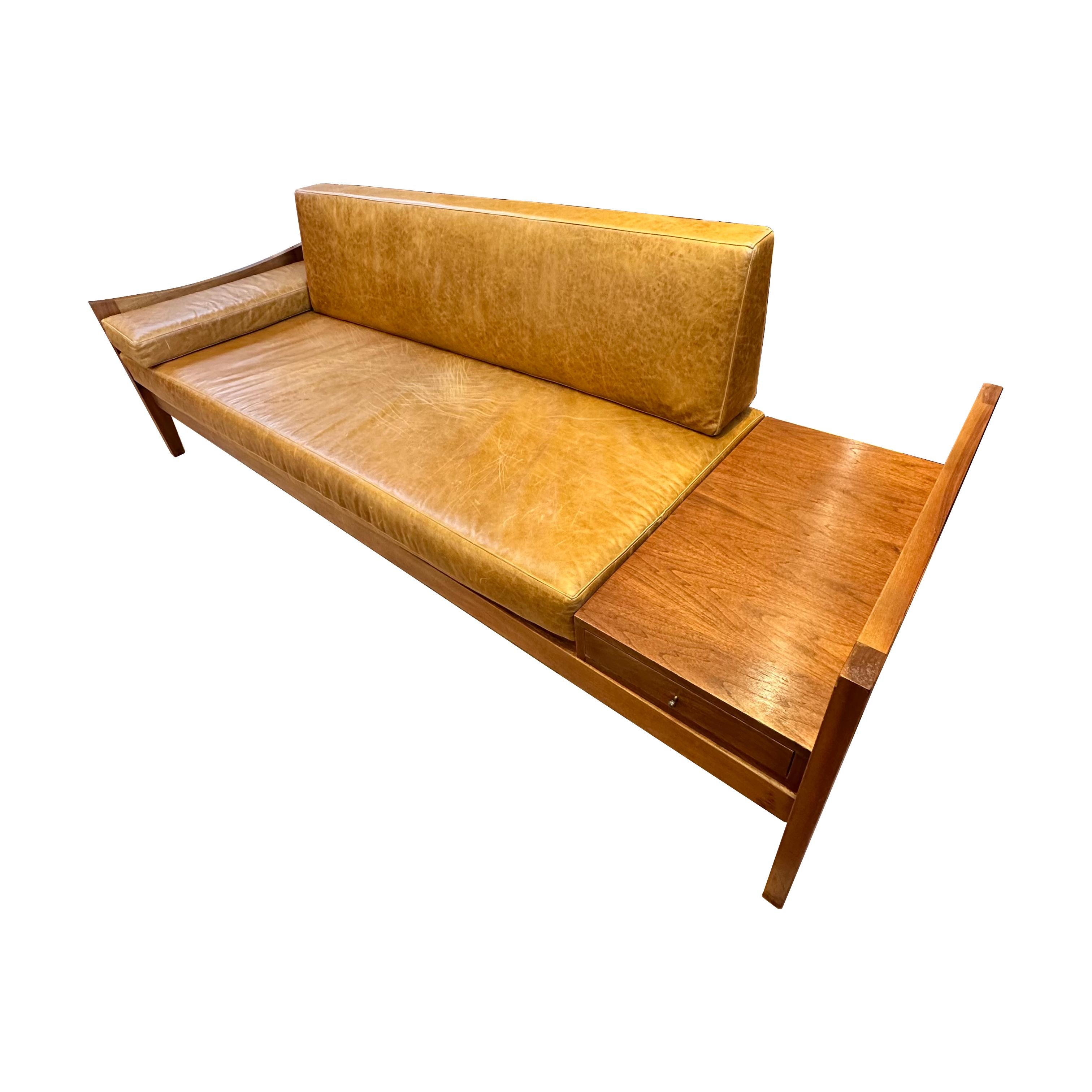 Lane mid-century modern walnut and leather sofa with built-in end table. A stunning piece that seamlessly blends style and functionality, the sofa has a walnut frame, and the seat, back, and side panels have been professionally reupholstered in