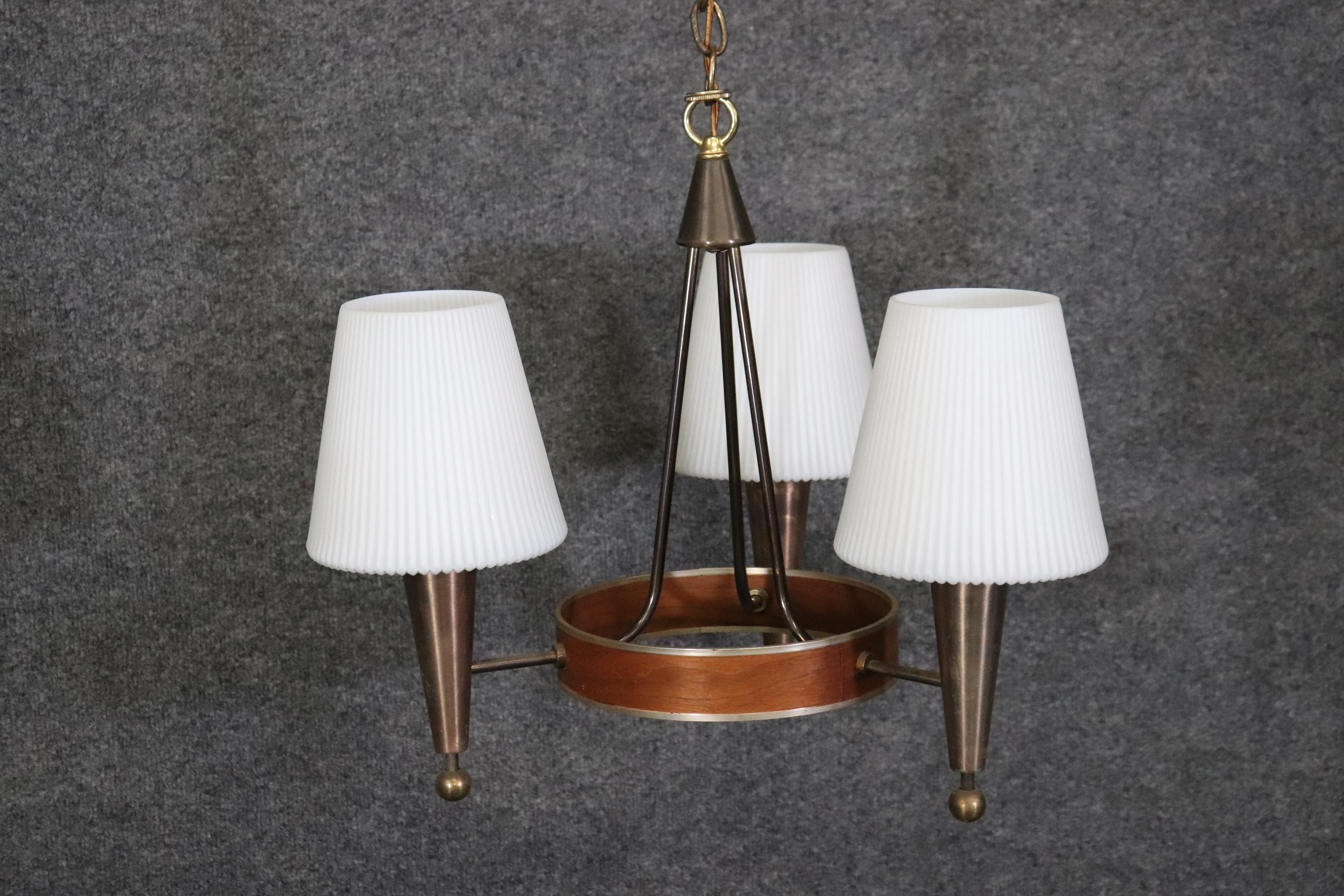 Dimensions- H: 18in W: 19 1/2in D: 19 1/2in

This Mid Century Modern three light chandelier is something to be seen!  Lightolier produced this walnut and brass chandelier. Lightolier was founded in 1904 by Bernhard Blitzer. Its original name was the
