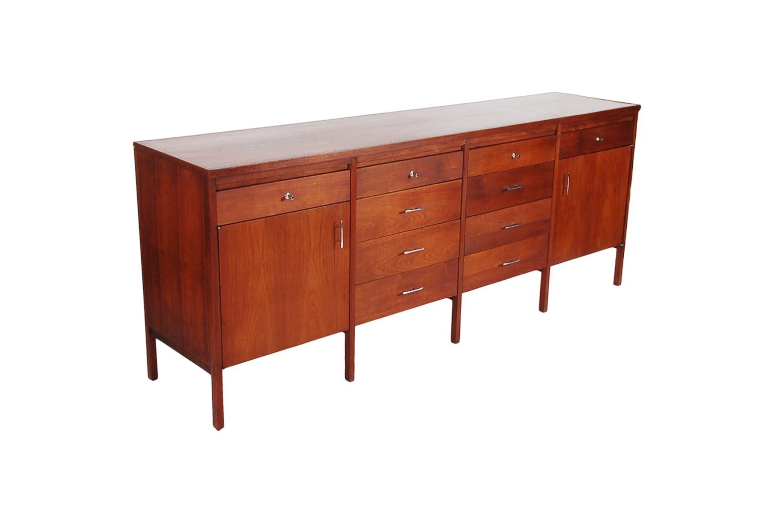 A chic and classic American modern credenza, circa 1960s. It features two finish woods, both walnut and rosewood. Stylish 8 leg design with tons of storage.