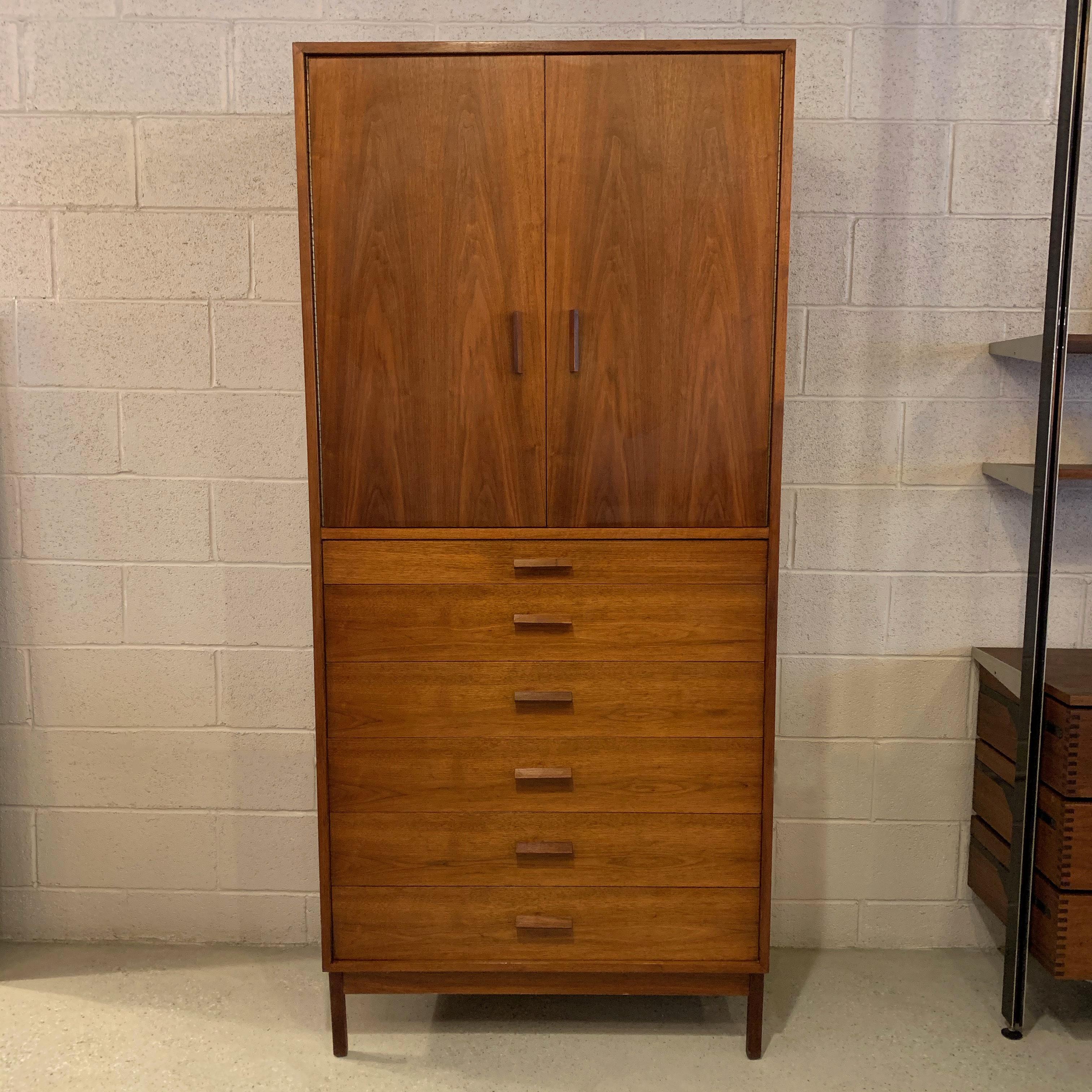 Handsome, Mid-Century Modern, walnut armoire or gentleman's chest features 6 drawers on the bottom half and upper cabinet with two adjustable shelves on each side and pullout / pull-out shelves in the middle.