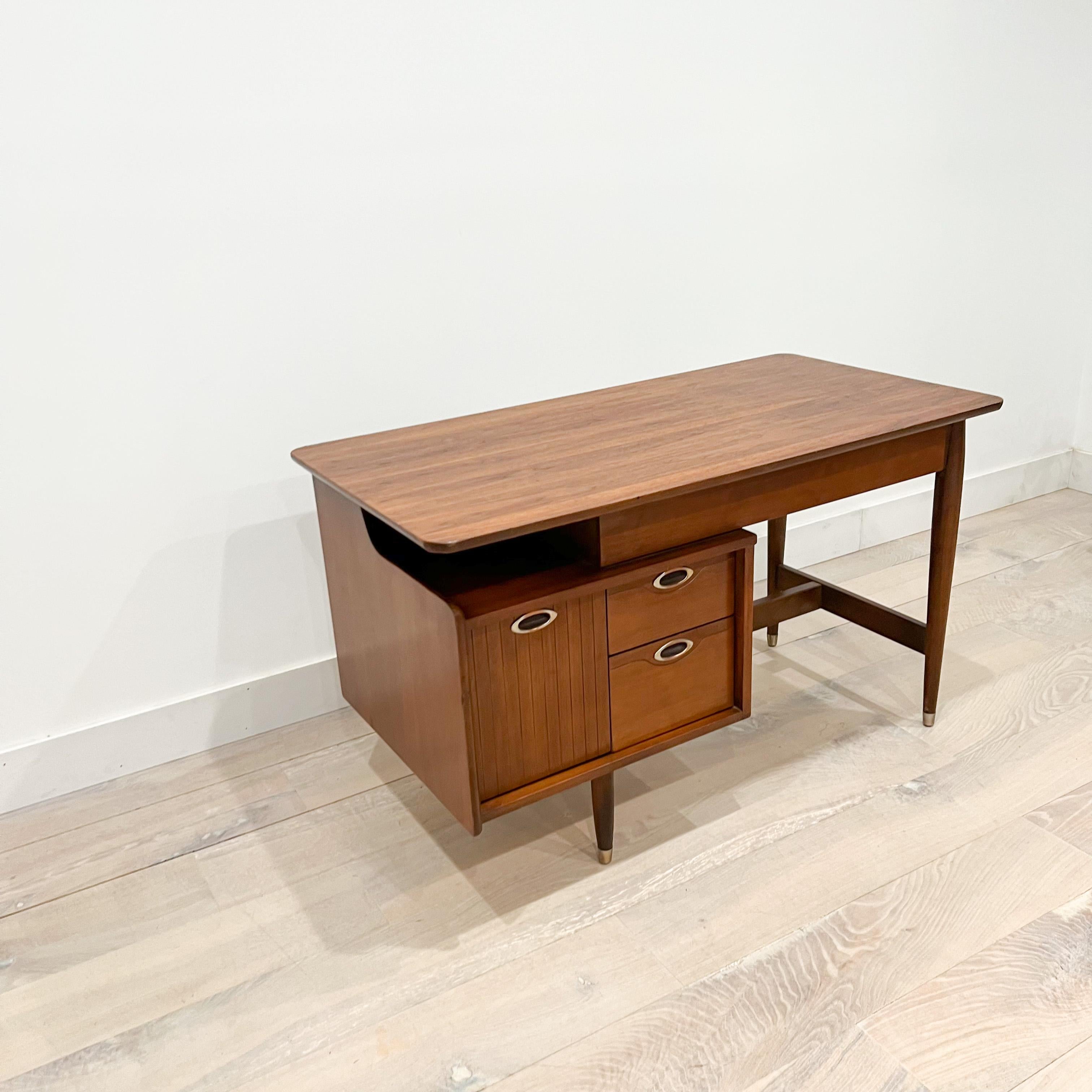 Mid-Century Modern walnut desk was manufactured by Hooker Furniture, as part of the 