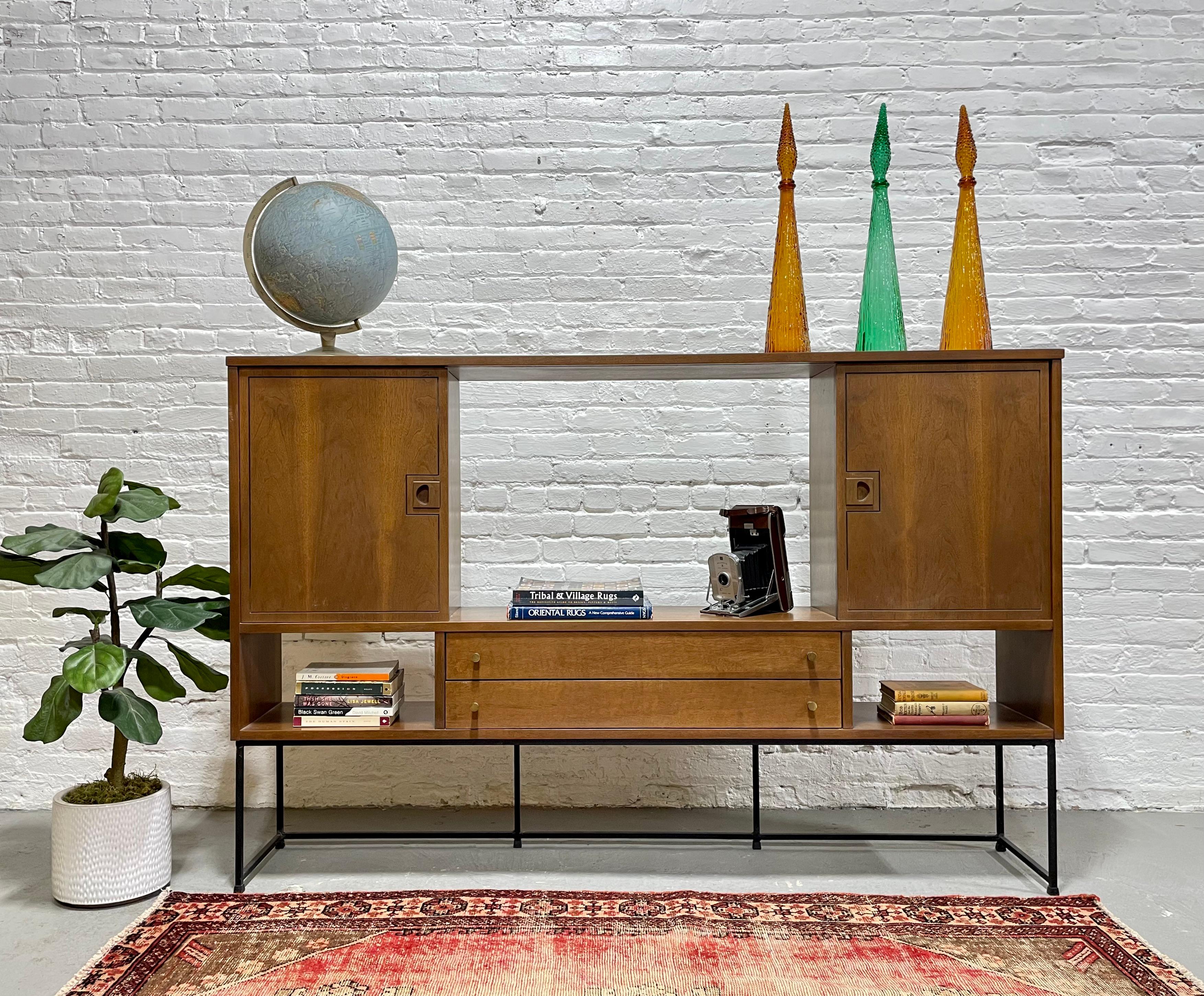 Mid Century Modern bar / bookcase by Stanley Furniture Company, circa 1960s.  This unique piece features sliding doors at the top with large cube-shaped compartments behind so you can hide or showcase your collection or liquors. A wide display shelf