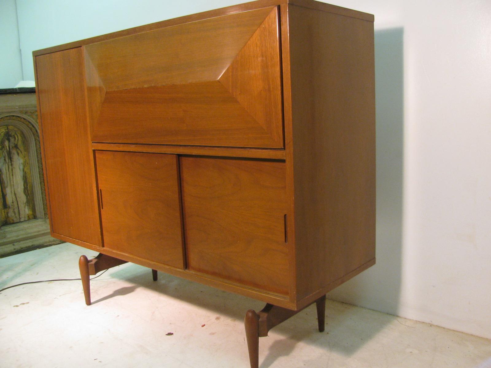 Beautifully designed liquor cabinet with locking push door hardware, laminate work shelf, lighted bar, mirror backed which pulls forward when you open the door, double sliding doors, storage areas with shelves that are adjustable. Solid walnut