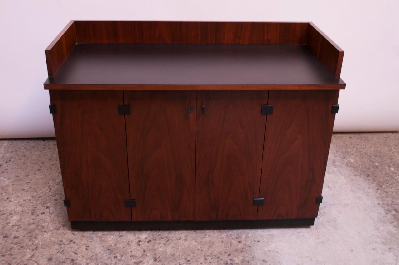 This walnut bar cabinet was manufactured by Directional in the 1960s and attributed to both Milo Baughman and Kipp Stewart due to stylistic attributes associated with both designers, but lack of source material to support. Most commonly credited to