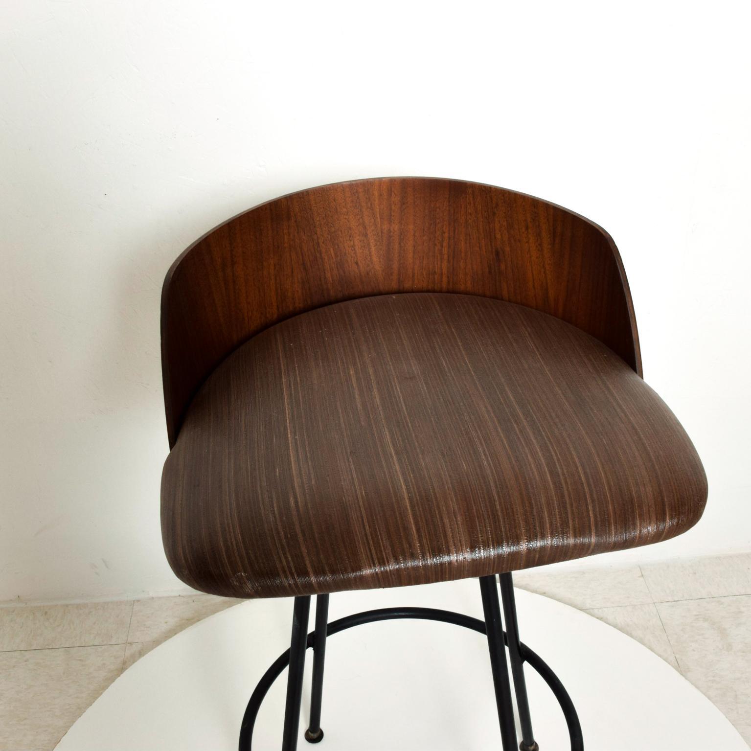 We are pleased to offer for your consideration, a rare and beautiful sculptural barstool designed by Chet Beardsley. Round bent walnut plywood with tubular steel in black color with the original modern vinyl upholstery. Made in the USA circa 1960s.