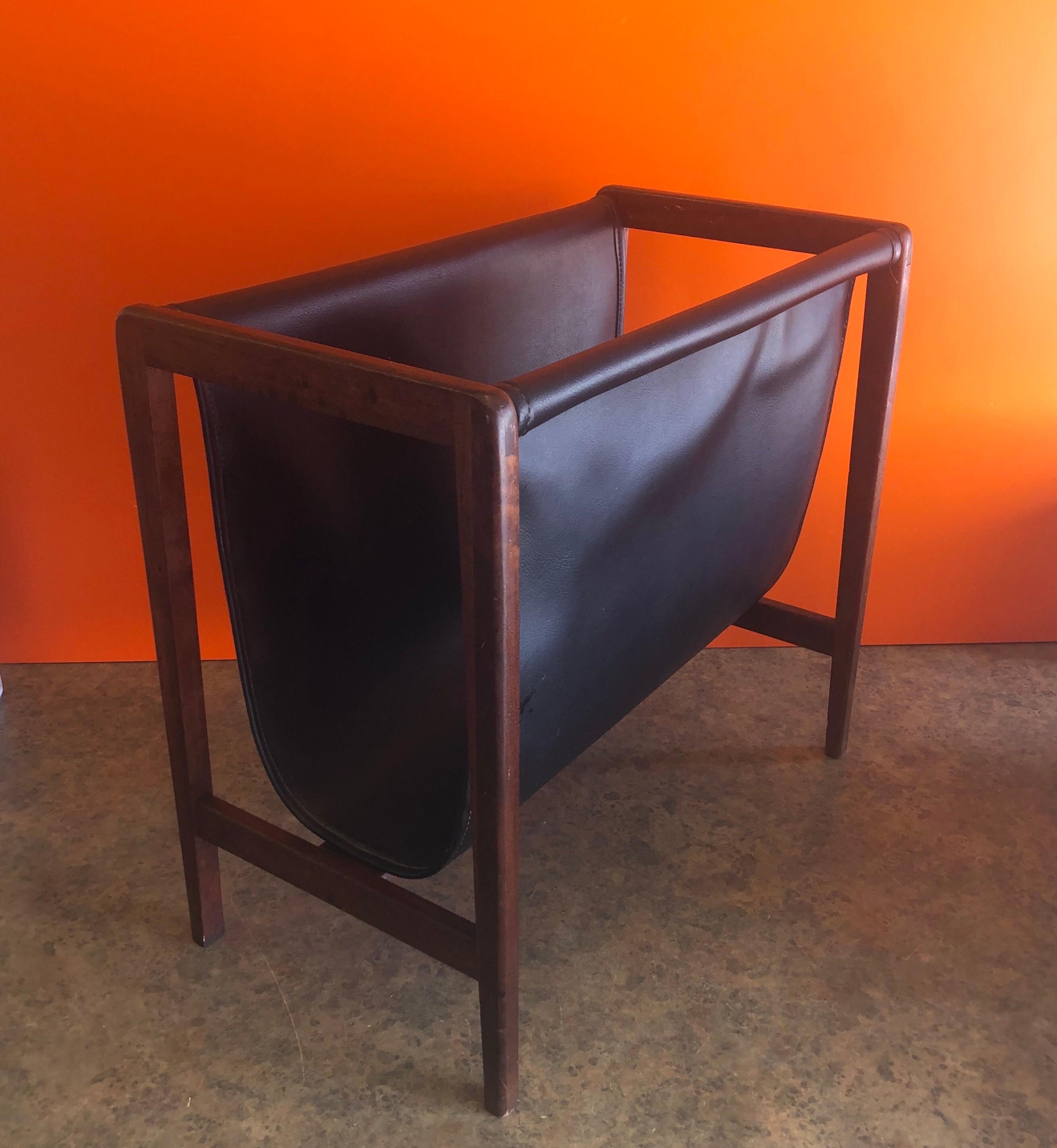 Mid-Century Modern walnut and black naughayde magazine rack, circa 1970s. A solid walnut frame and a dark black Naugahyde insert make this a very attractive and functional magazine rack for any MCM room. #1207.