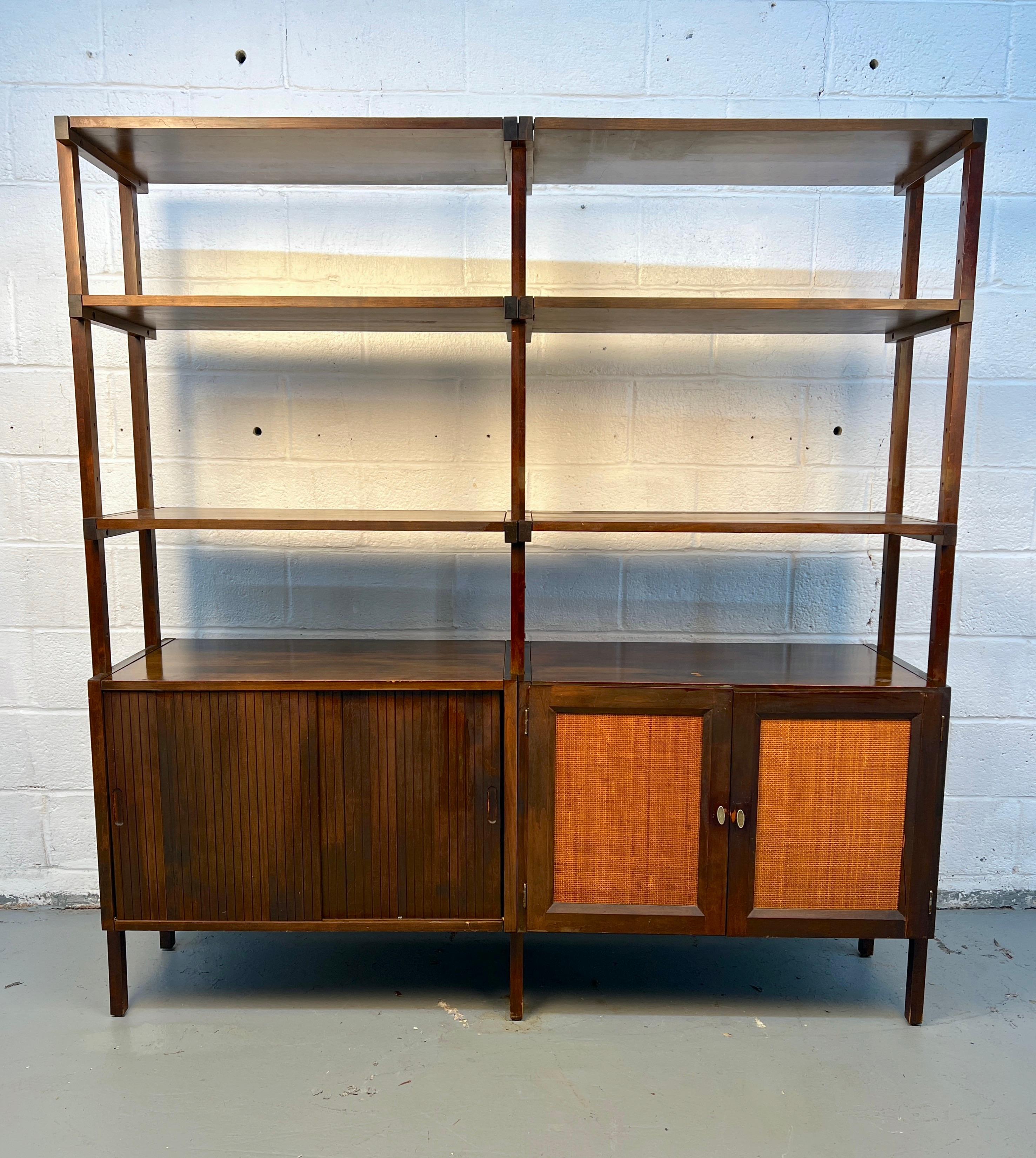 Bellissima libreria in noce moderna di metà secolo caratterizzata da linee pulite, scaffali aperti e un mobile inferiore con ante scorrevoli in vimini testurizzato. Un perfetto connubio tra materiali naturali e design elegante, che offre sia