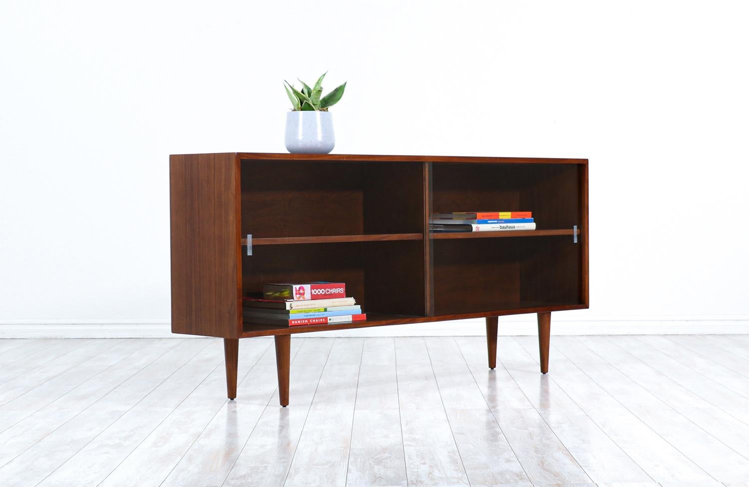 Mid-Century Modern walnut bookcase with glass doors.