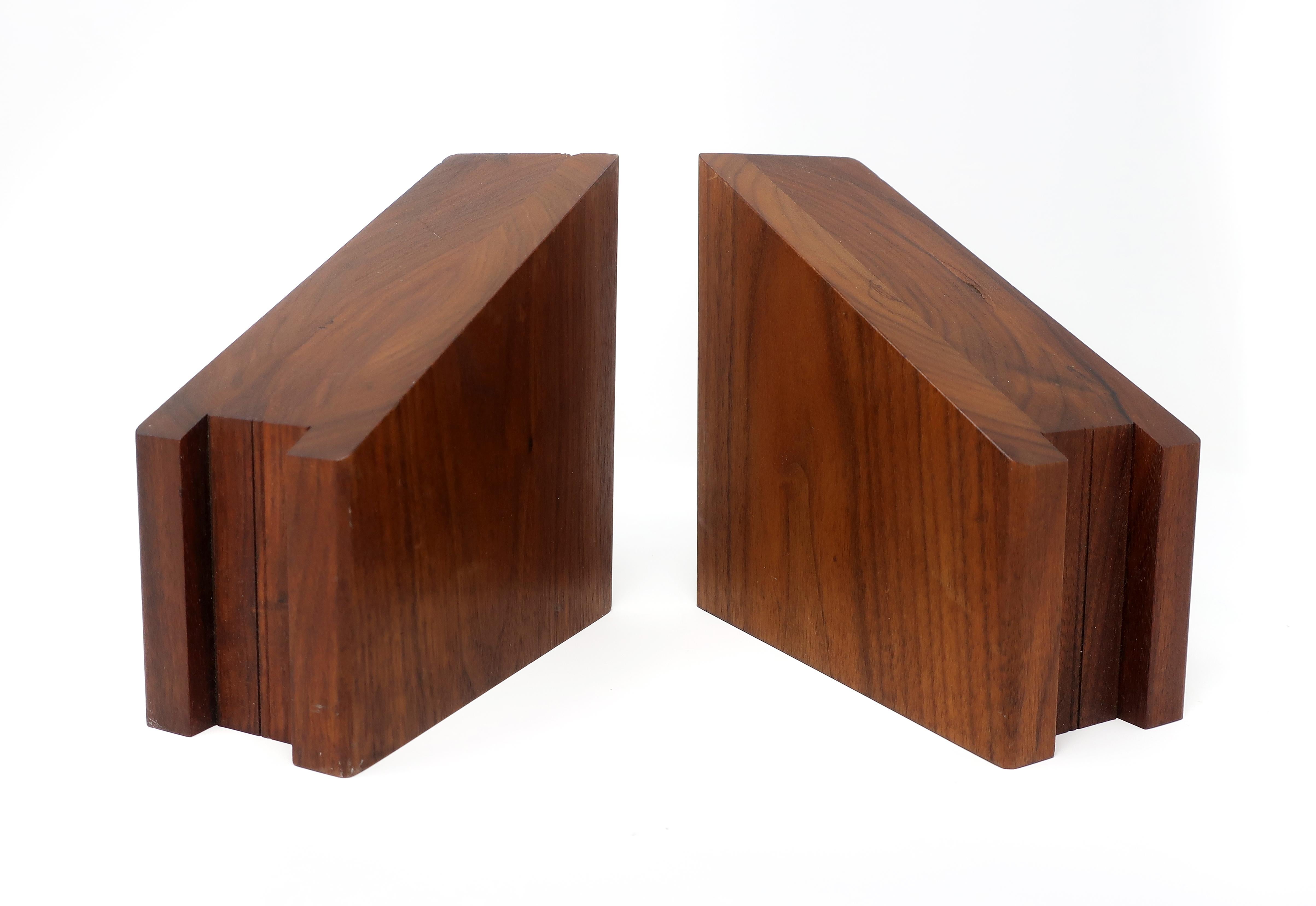 A pair of Mid-Century Modern walnut bookends with one angled side and one with a channel cut into it. With two flat sides, these can be positioned to have the channeled side up or down. In good vintage condition with some wear consistent with age