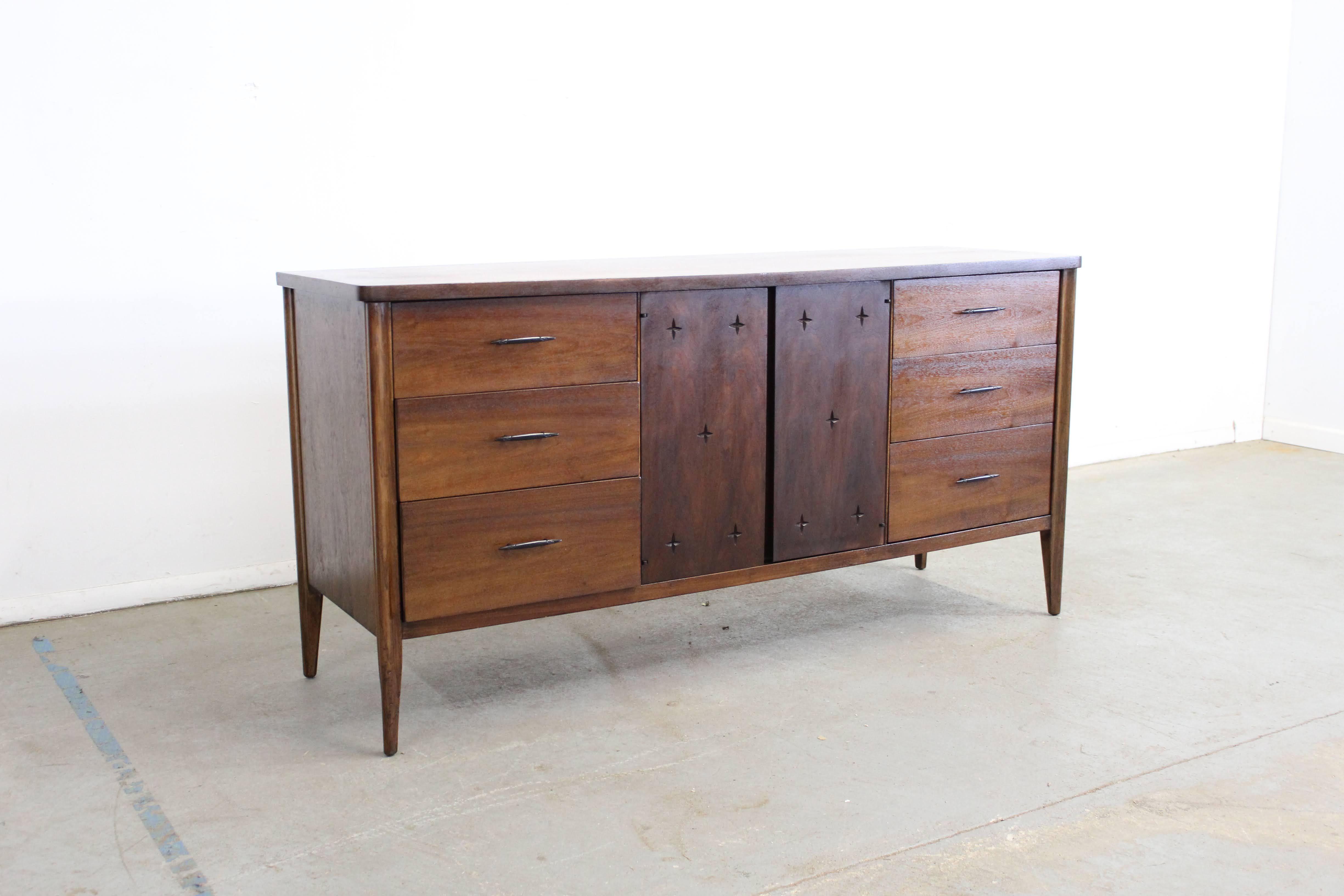 Offered is a walnut credenza. Features 6 drawers with 2 cabinets that reveal 3 more drawers.It is in good condition, showing some age wear, (surface scratches/chips, watermark on top, vintage wear-- see pictures) but nothing overly bothersome