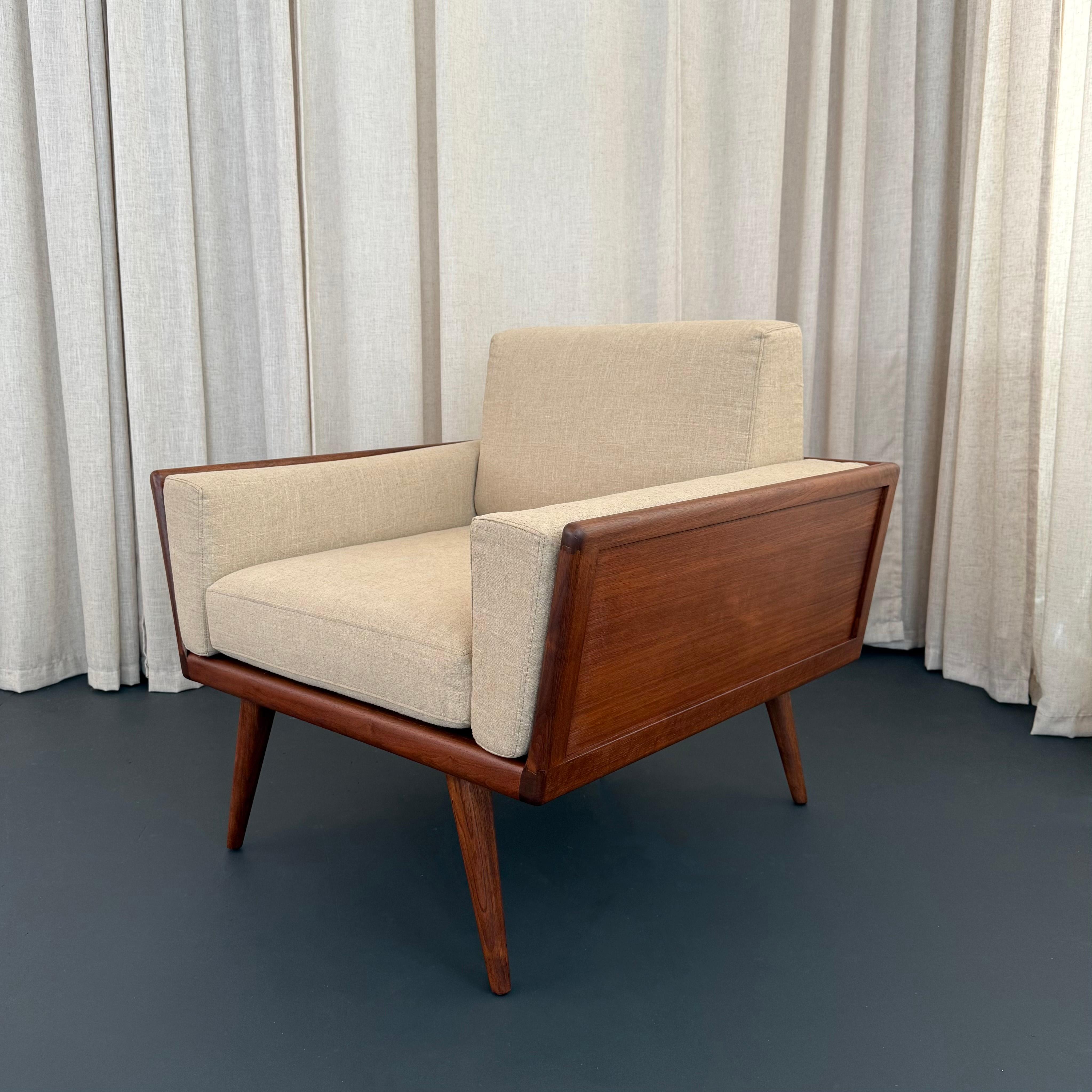 This stunning Mid-Century Modern case armchair was designed by American designer Mel Smilow for Smilow's joint firm, Smilow-Thielle furniture, circa 1950s. The club chair features an exposed solid walnut case with coffered panels raised on slender
