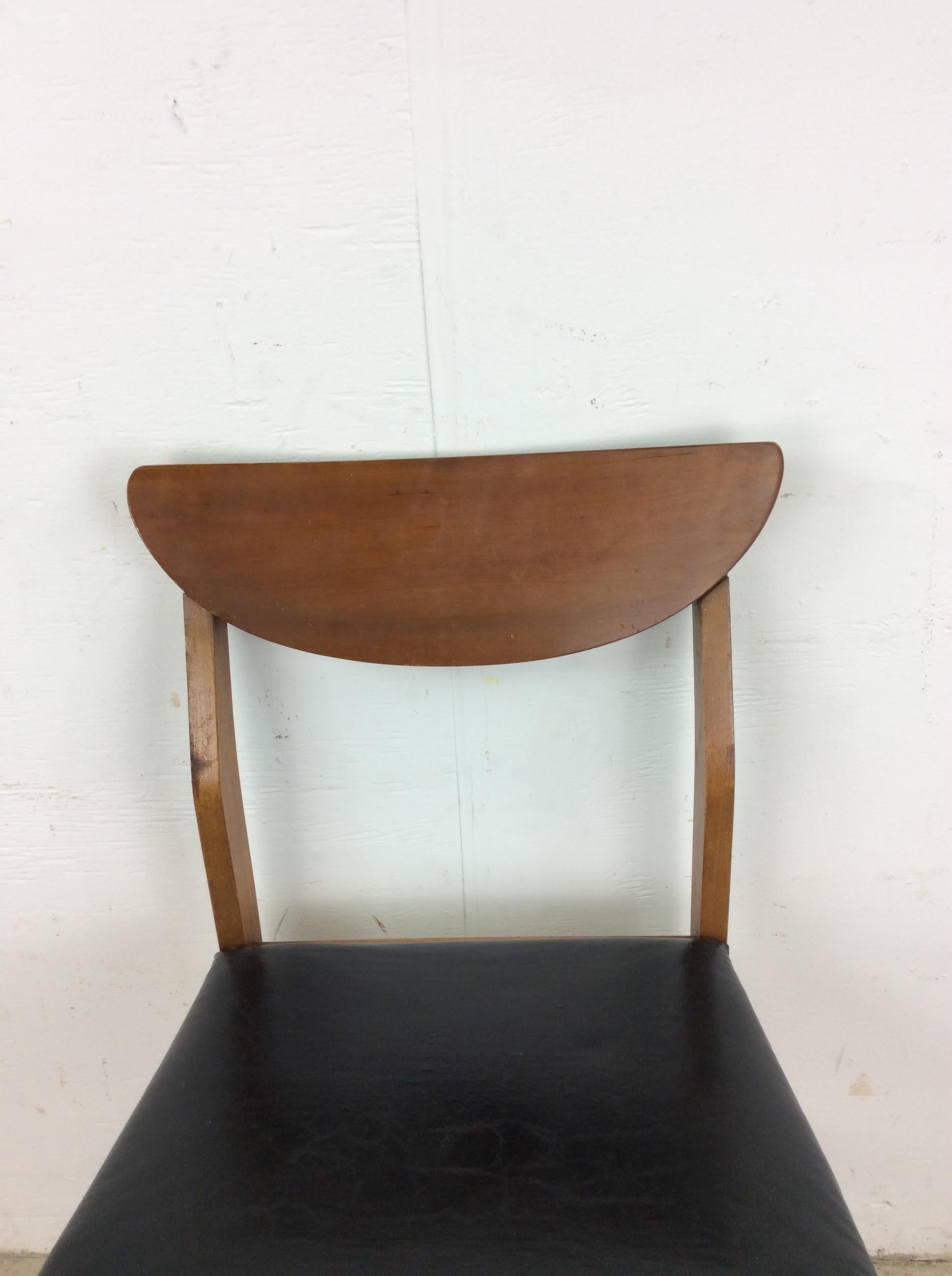 Questa poltrona moderna di metà secolo è realizzata in legno massiccio, con finitura originale in noce, rivestimento in vinile nero e alte gambe affusolate.

Dimensioni: 18w 18d 31,5h 17sh 

Note sulle condizioni: La finitura originale del telaio in