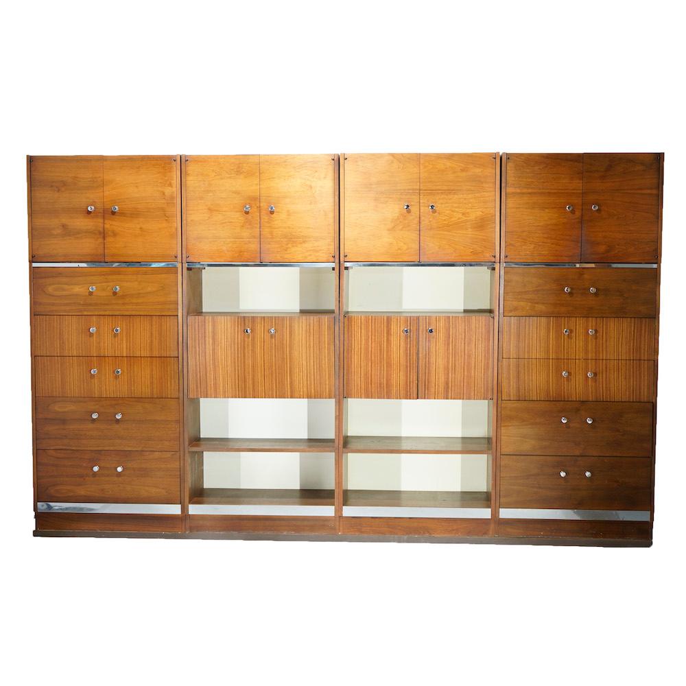 A Mid-Century Modern four-piece modular unit offers walnut construction with chrome trim and hardware and includes secretary, shelving, cabinets and drop down desk, en verso serial number 3177111, 20th century

Measures- 78''H x 32''W x 19''D;