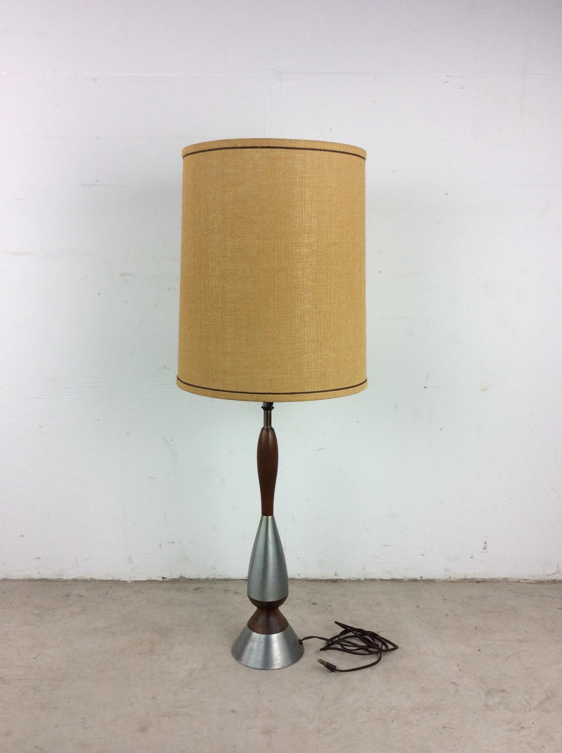 This mid century modern table lamp features chrome & walnut base, original wiring, and vintage barrel shade.

 Dimensions: 13w 13d 39h

Condition: Original wiring works. Vintage shade is in good condition. The chrome & walnut on the base have some
