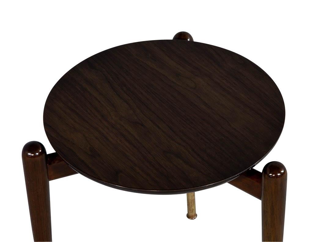 Mid-Century Modern circular end table with tree turned ending and original brass sabots.
 